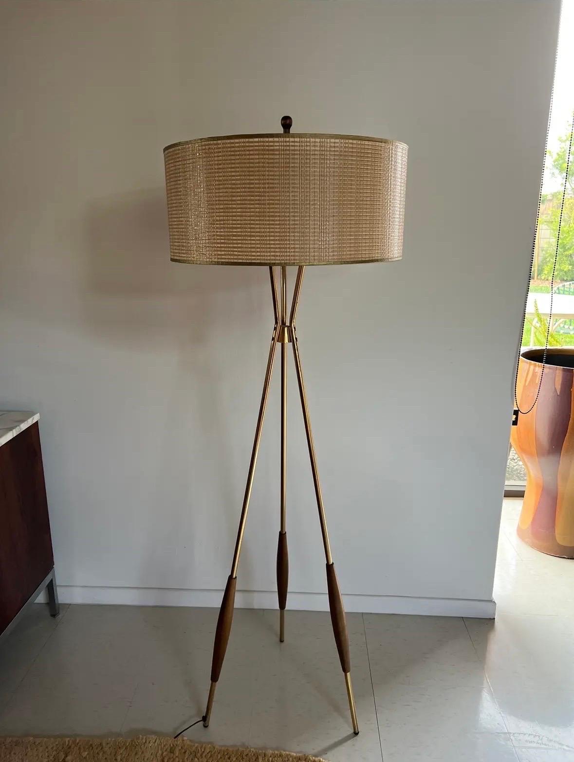 Lampadaire tripode en laiton de Gerald Thurston pour Lightolier. Pieds en laiton avec accents en noyer. L'abat-jour et l'embout d'origine ont été conservés. Tête de lampe à 3 douilles en parfait état de fonctionnement.

Expédition depuis Orange,