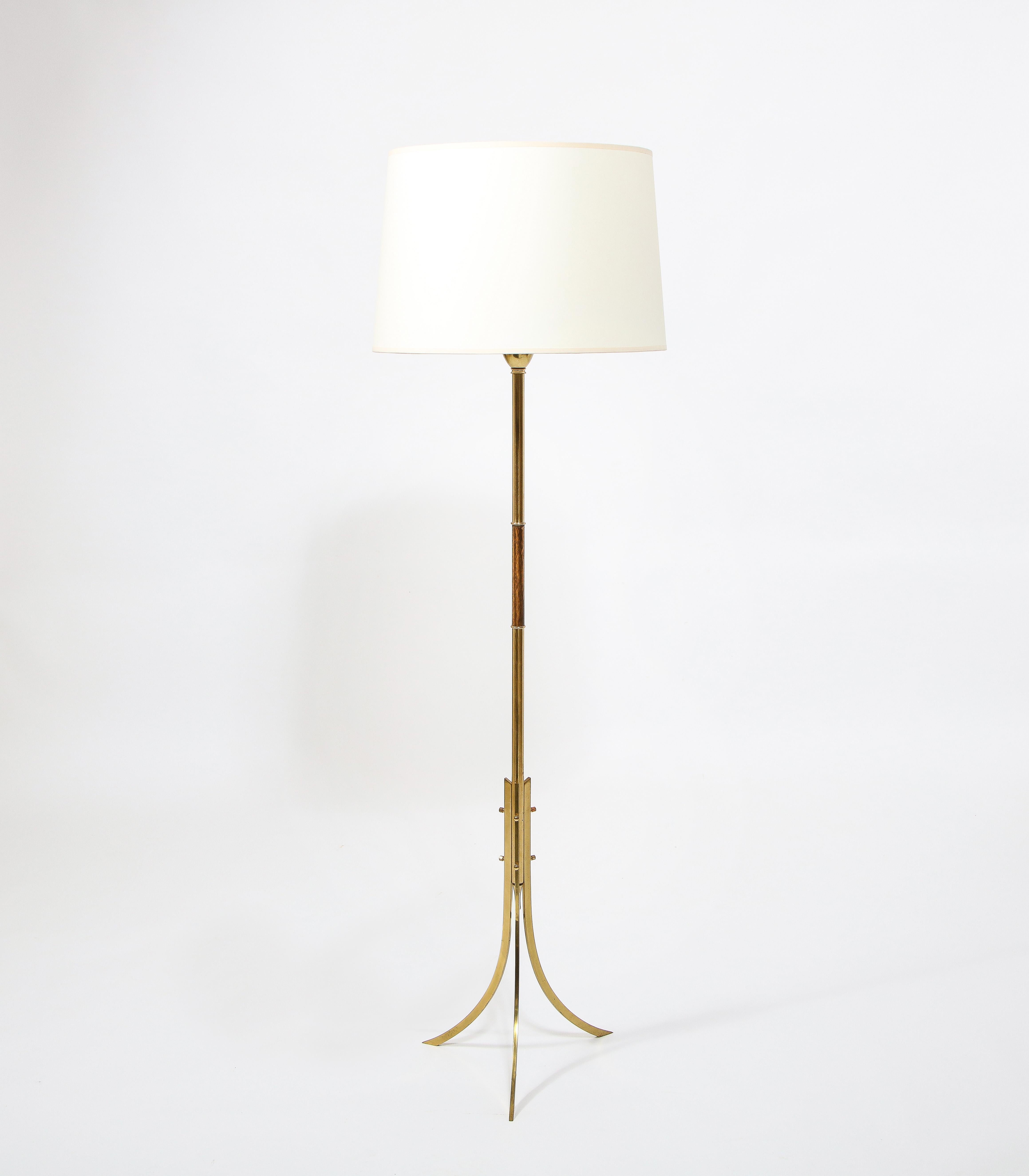 Minimal tripod floor lamp in brass, the legs are three curved blades of brass bolted to the stem with accorn nuts. Shade is for photographic purposes.