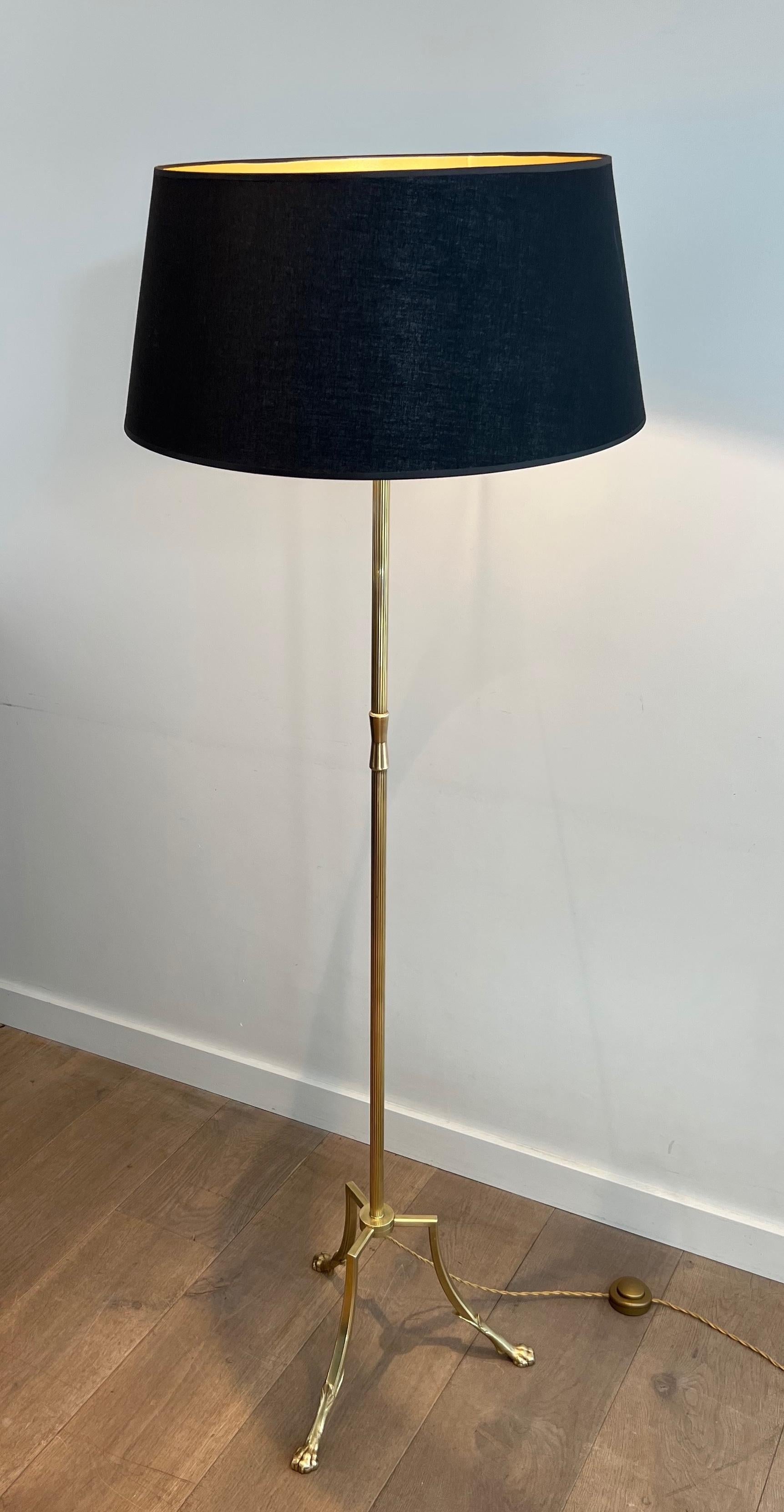 Questa bella ed elegante lampada da terra tripode in stile neoclassico è realizzata in ottone con piedi ad artiglio. Questa è un'opera francese di Maison Jansen. Circa 1940
