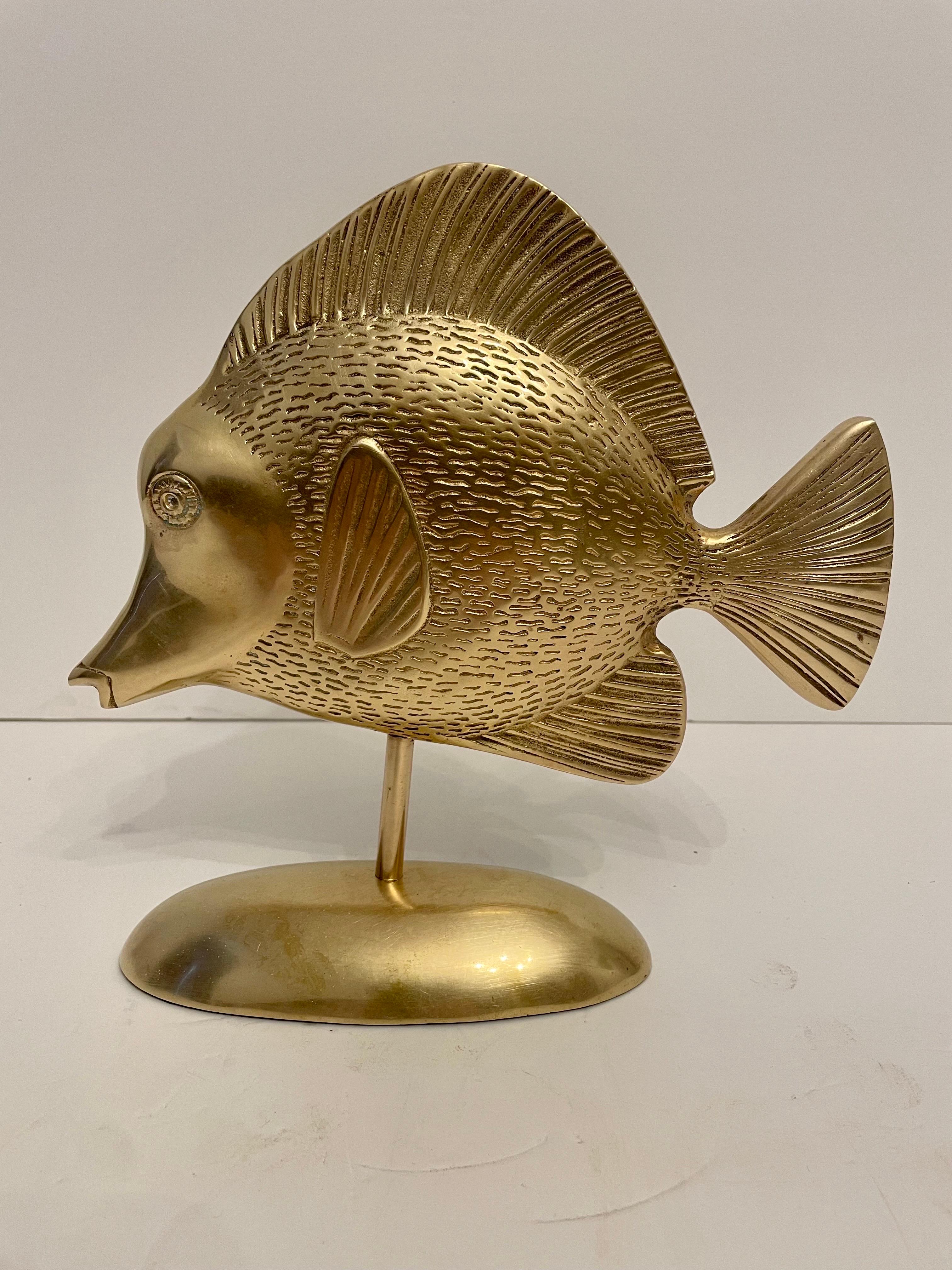 Brass Tropical tang fish sculpture on stand. Rubbery felt on bottom of base with Made In Korea sticker. Overall good condition. Dark and light spots in photos is reflection. Will look great on desk or bookcase.