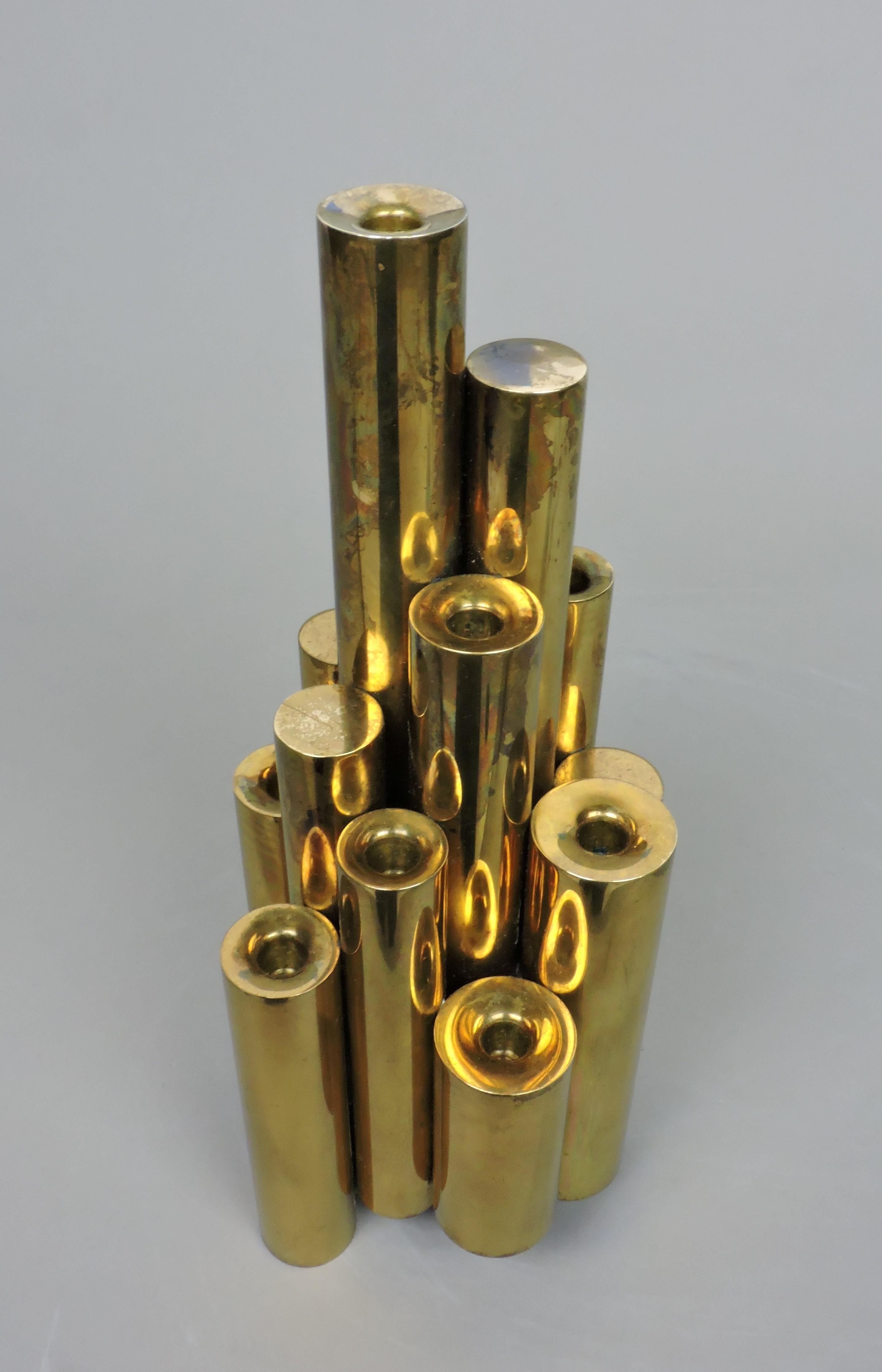 Beautiful solid brass candle holder attributed to Gio Ponti. This candle holder consists of thirteen tubular forms of various heights and holds nine candles.