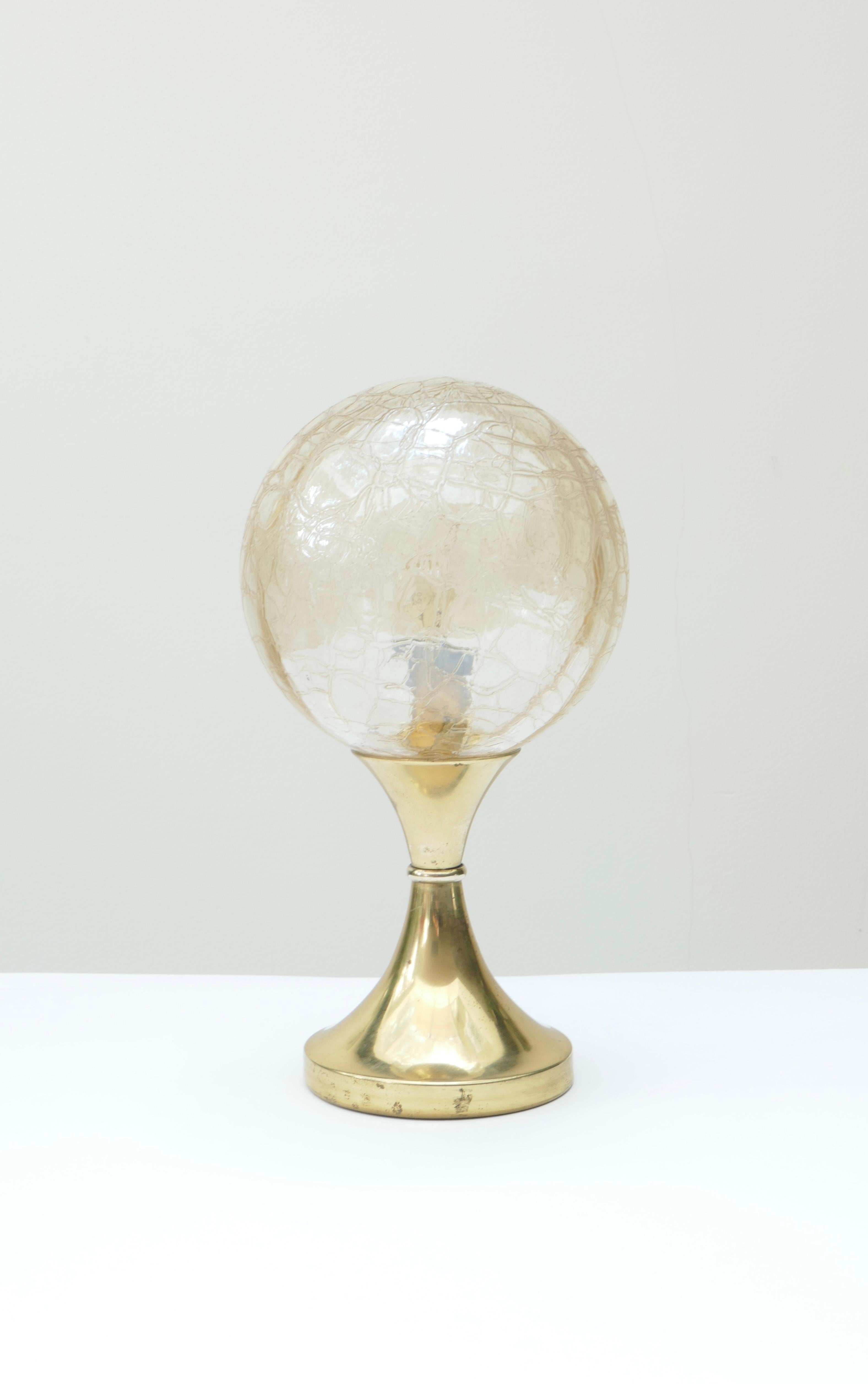 A unique small table lamp with a tulip brass base and a crackle glass globe shade that diffuses a warm light.
Unique and easy to place in any room to add light and warmth. 
Measures: Base diameter : 11 cm. 
Globe diameter : 20 cm. 
Height 29