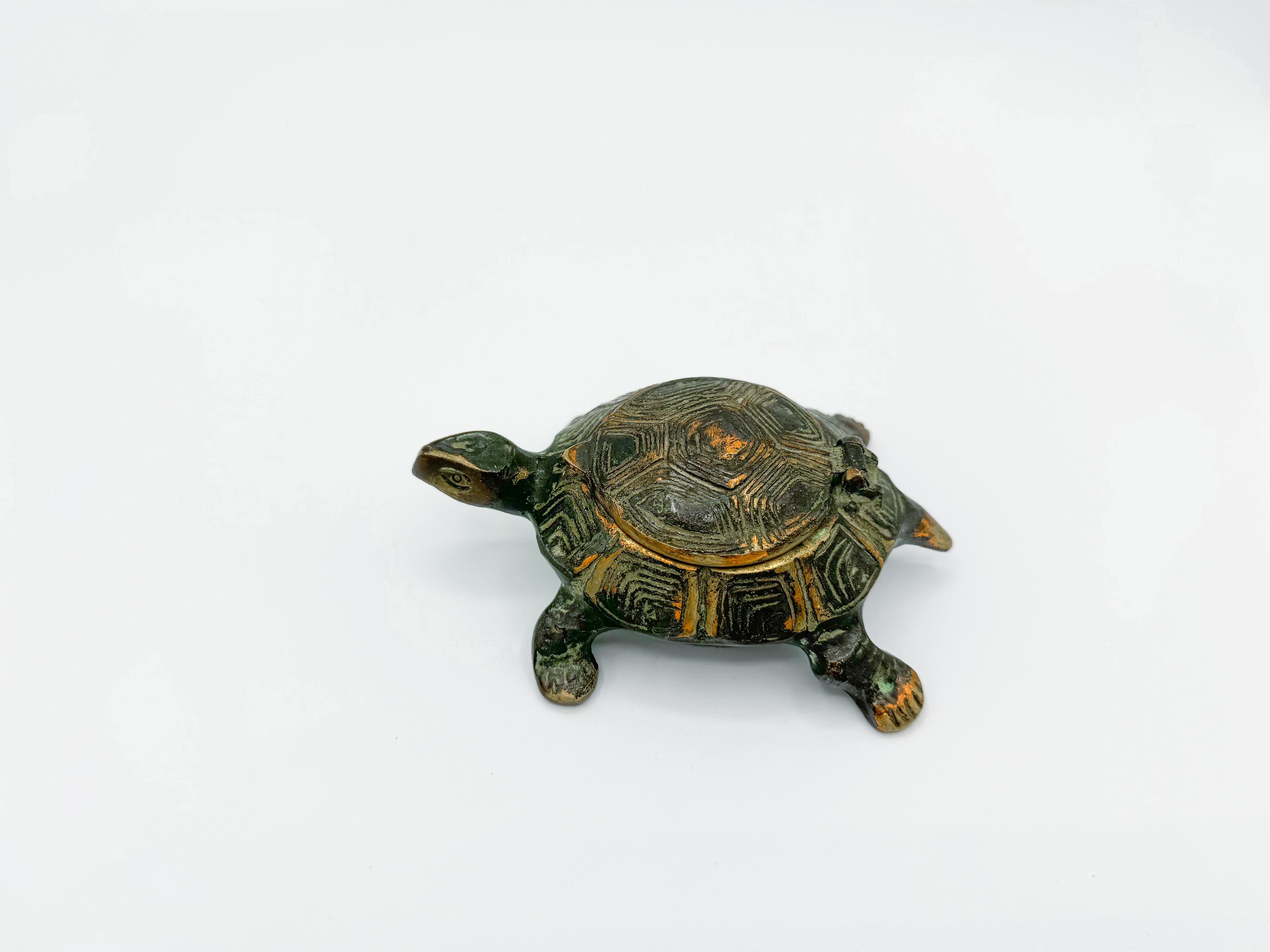 Vintage Brass Turtle Ashtray featuring a unique flip-top cigarette holder. Crafted from solid brass, this whimsical piece showcases a rich blue-green patina, adding an extra touch of vintage allure. The turtle's detailed design and sturdy