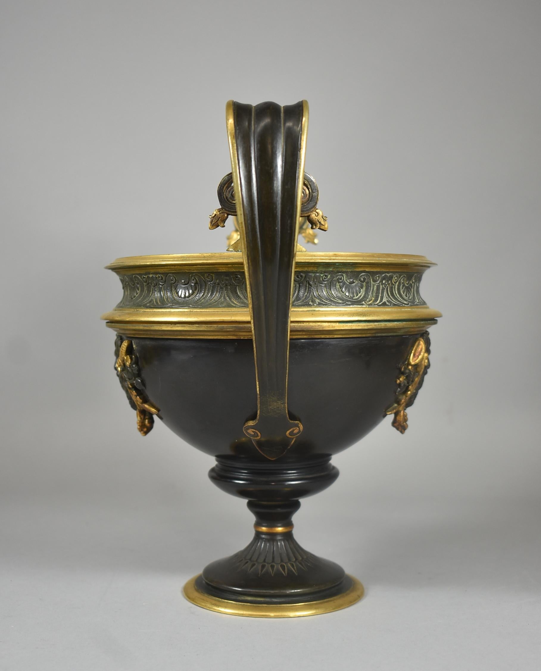 Brass two handled compote / urn centerpiece with figural center male face relief surrounded by grapes, horns and pinecones.