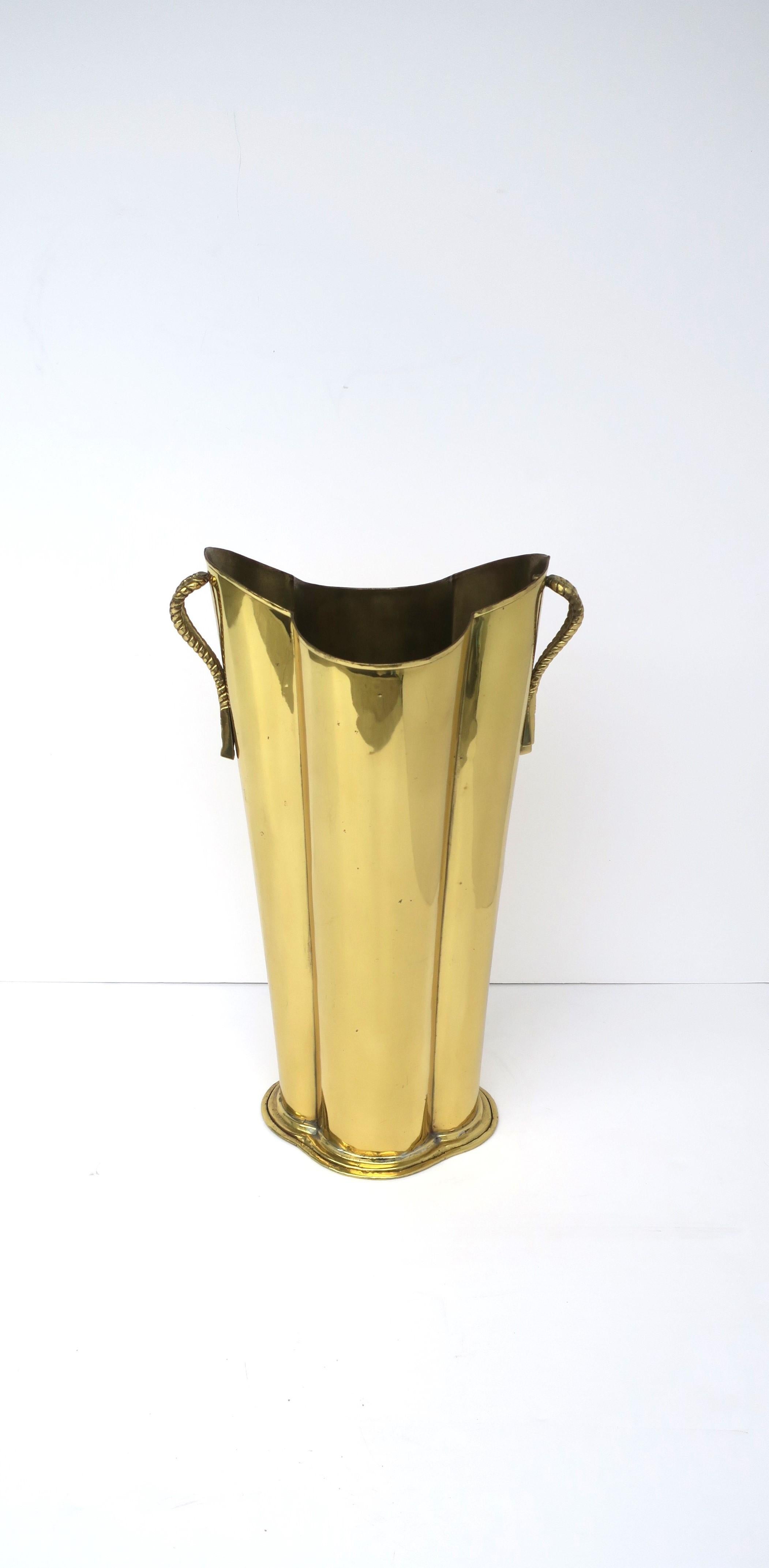 A brass umbrella holder stand with quatrefoil shape and tassel rope handles, circa late-20th century. 

Dimensions: 8.32
