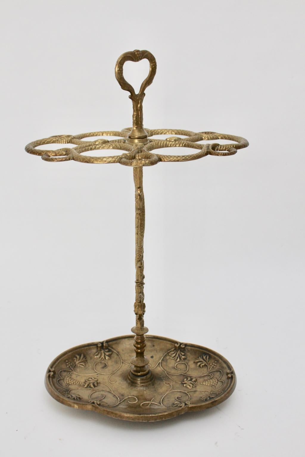 Hoolywood Regency Style vintage brass umbrella stand richly decorated with grapes and snakes. The umbrella stand shows good condition with signs of age and use like great brass patina.
Throughout the heavy material brass the umbrella stand features