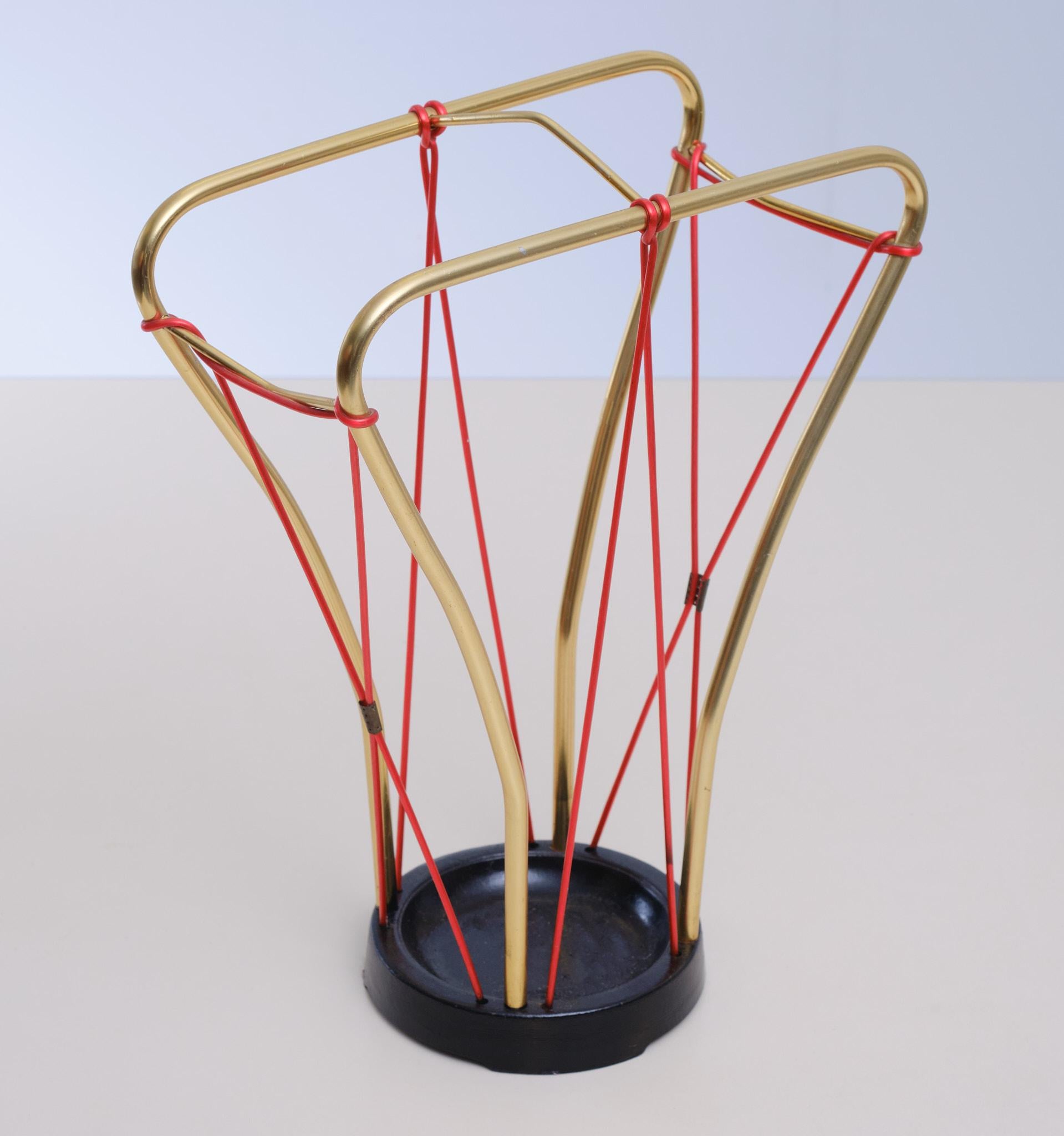Very nice umbrella stand. Brass connected by Red Plastic wire. Cast Iron base. all original.
Typical Austria 1950s.