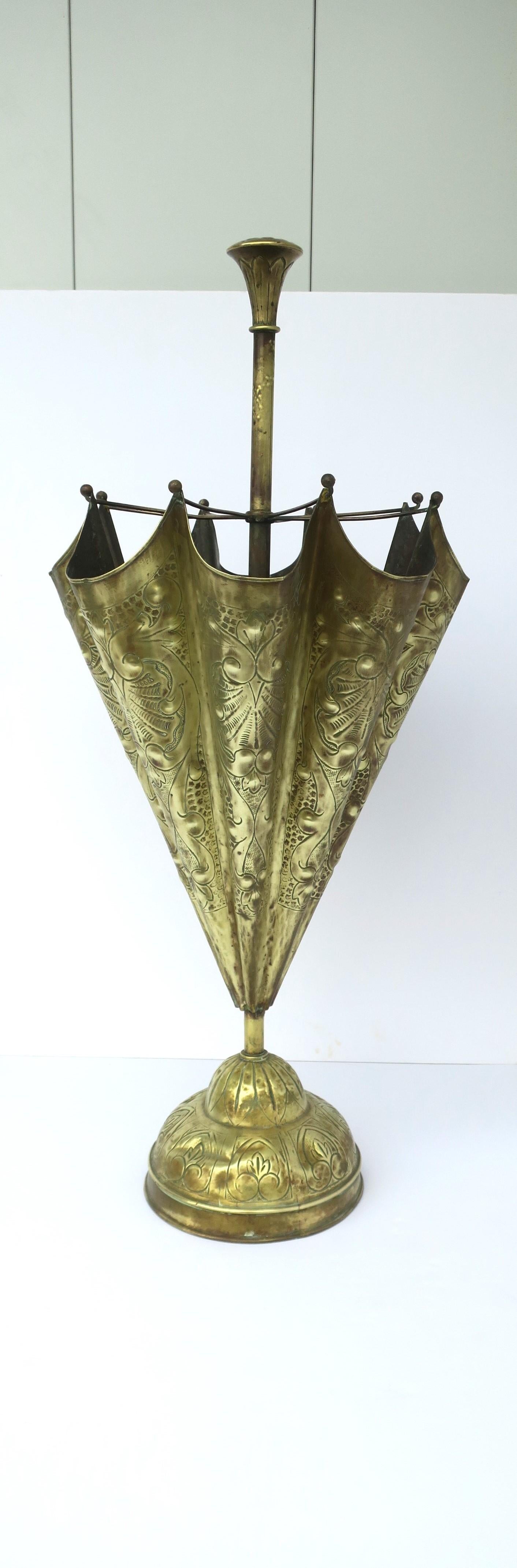 A beautiful brass umbrella holder stand in an 'Umbrella' shape with repousse design, circa mid-20th century. This is a 'wow' of an umbrella holder stand with its detailed 'Umbrella' design from top to bottom and grand scale. Piece is shown next to
