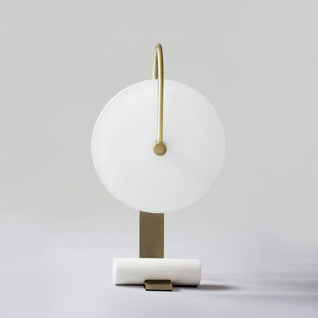 Brass Universe Table Lamp by Square in Circle
Dimensions: H 43.5 x W 19 x D 7 cm
Materials: Brushed brass, white frosted glass, white onyx marble

Our glass disc light provides an ambient glow and is held in place by a single, arched arm from one