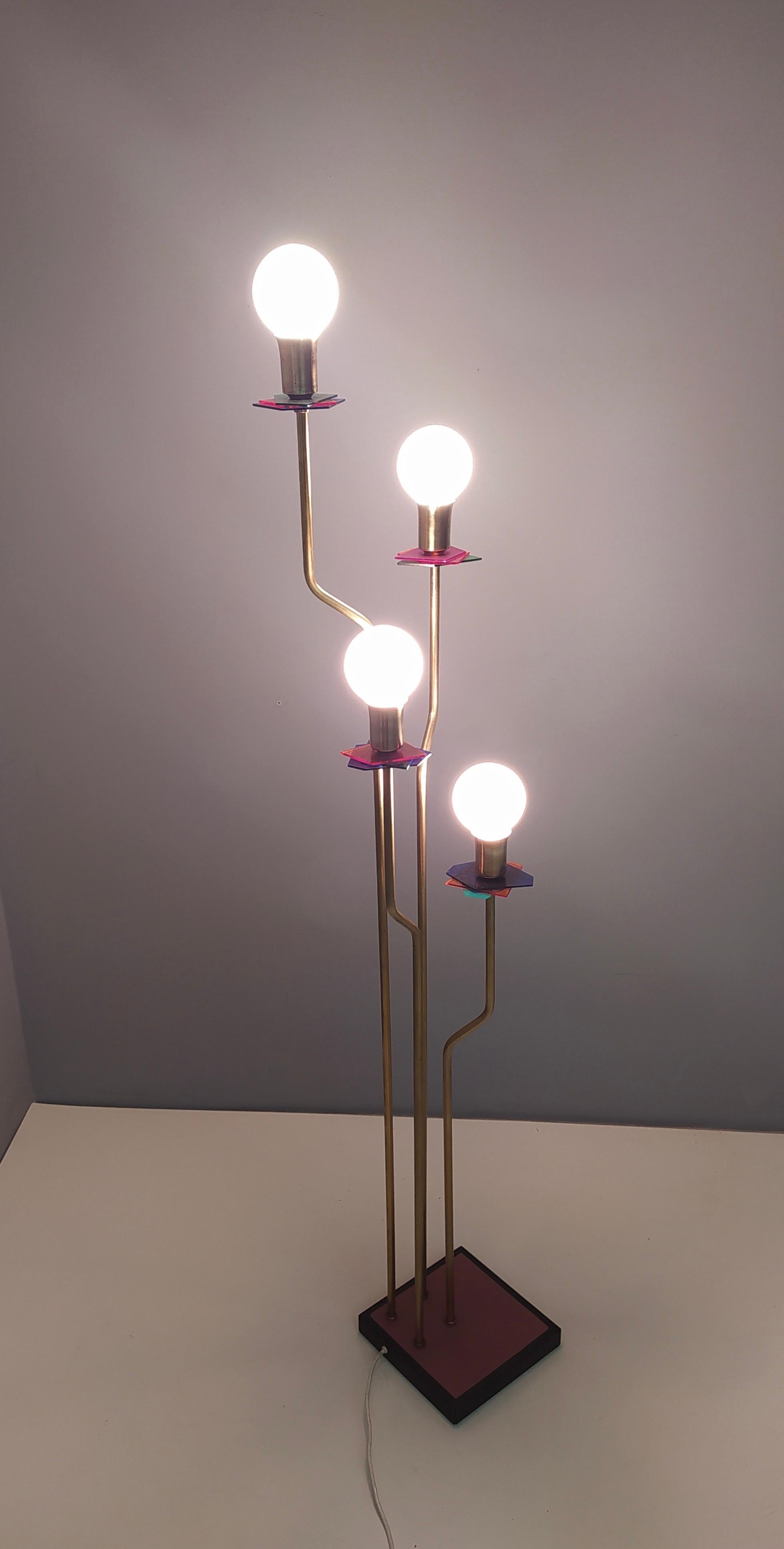 This floor lamp is made in brass, varnished metal and multicolored Plexiglas.
It might show slight traces of use, but it can be considered as in excellent original condition and ready to give ambiance to any room. 
One of a kind.

