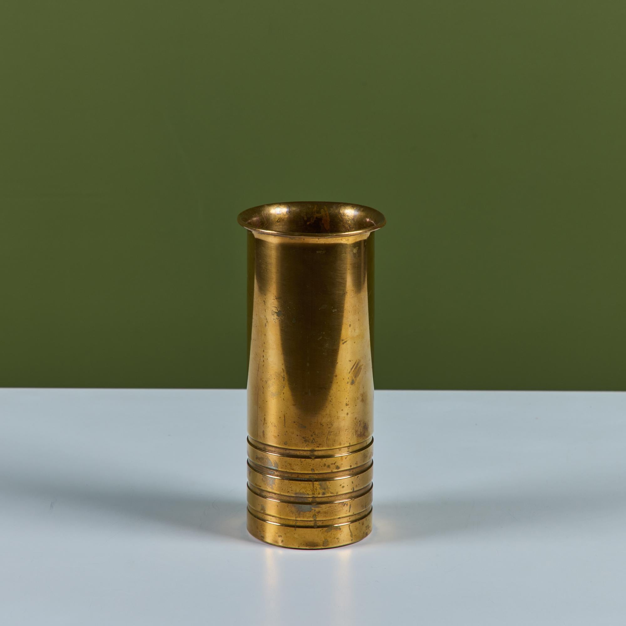 Vaso in ottone di Walter Von Nessen per Chase, anni '30 circa, USA. Il vaso in ottone massiccio patinato Art Deco presenta un'apertura a tulipano e quattro anelli incisi intorno al fondo del vaso. Impresso con [Chase] e con il logo Chase Minotaur