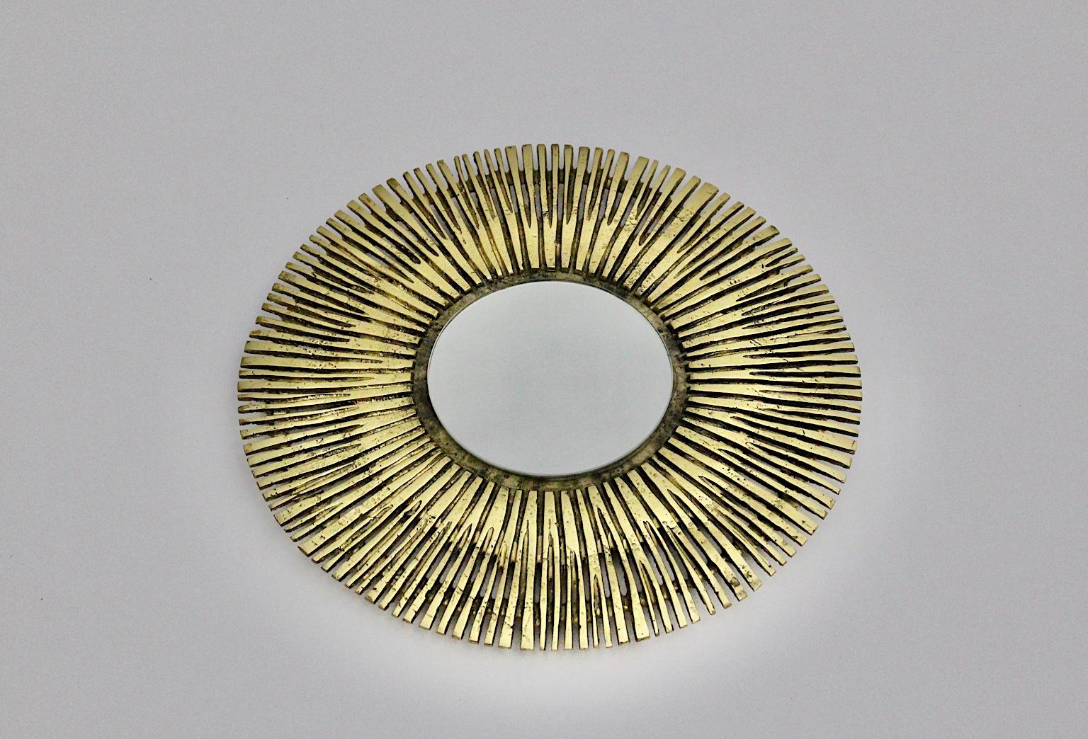 Brass Vintage Round Design Sunburst Mirror or Wall Mirror France 1960s.
A beautiful wall mirror or sunburst mirror in circular shape from solid cast brass and mirror glass. 
This extraordinary sunburst mirror is a wonderful piece from the range of