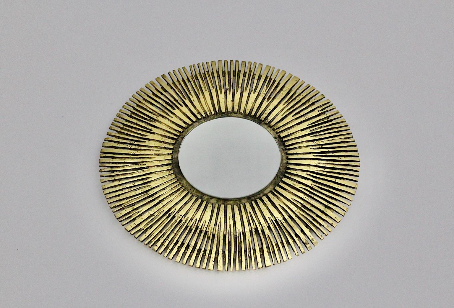 Specchio d'ottone vintage dal design rotondo o specchio da parete Francia 1960.
Un bellissimo specchio da parete o specchio a raggiera di forma circolare in ottone massiccio fuso e vetro a specchio. 
Questo straordinario specchio a raggiera è un