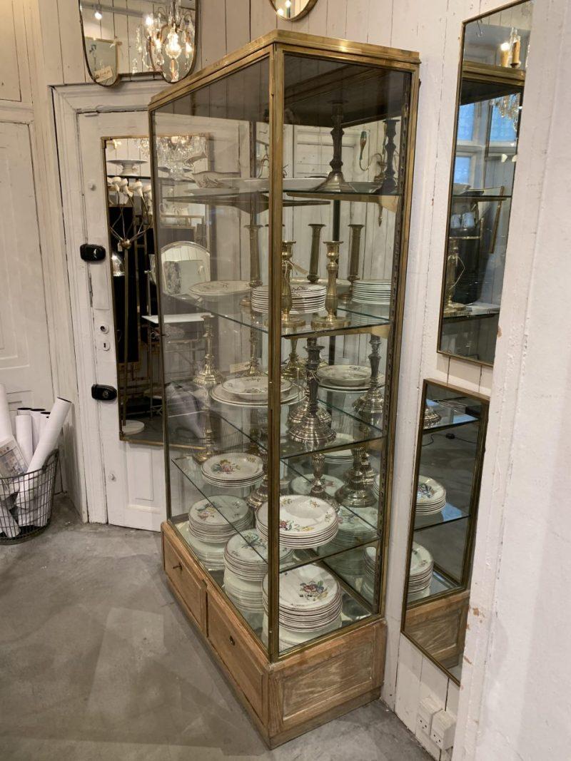 Handsome and beautifully proportioned French display cabinet from the beginning of the last century. Made of quality brass and glass and has an associated key, 4 beautiful large glass shelves with adjustable brass shelf jacks and mirrored glass