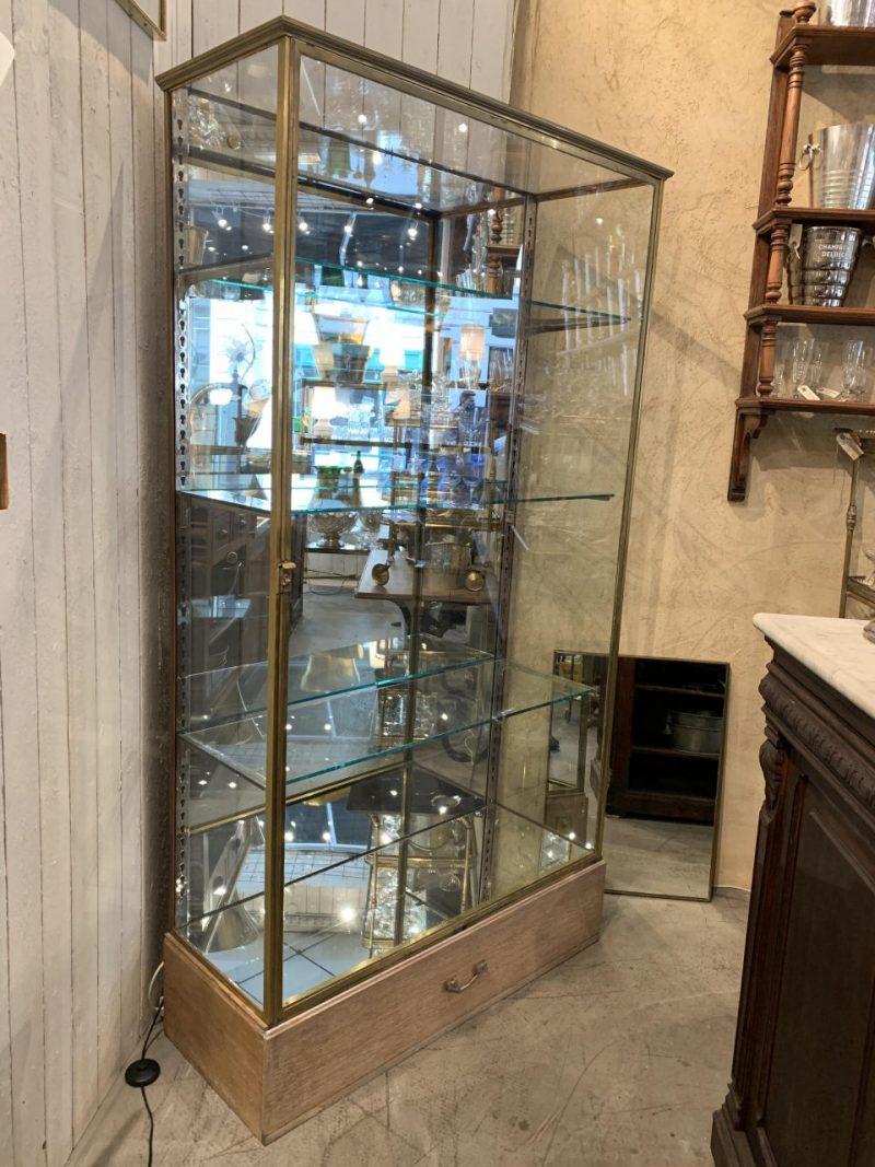 Handsome, large and very well-proportioned French vitrine from the beginning of the last century. Made of quality brass and glass, and equipped with 3 beautiful large glass shelves with adjustable chrome shelf jacks and mirrored glass backing. The