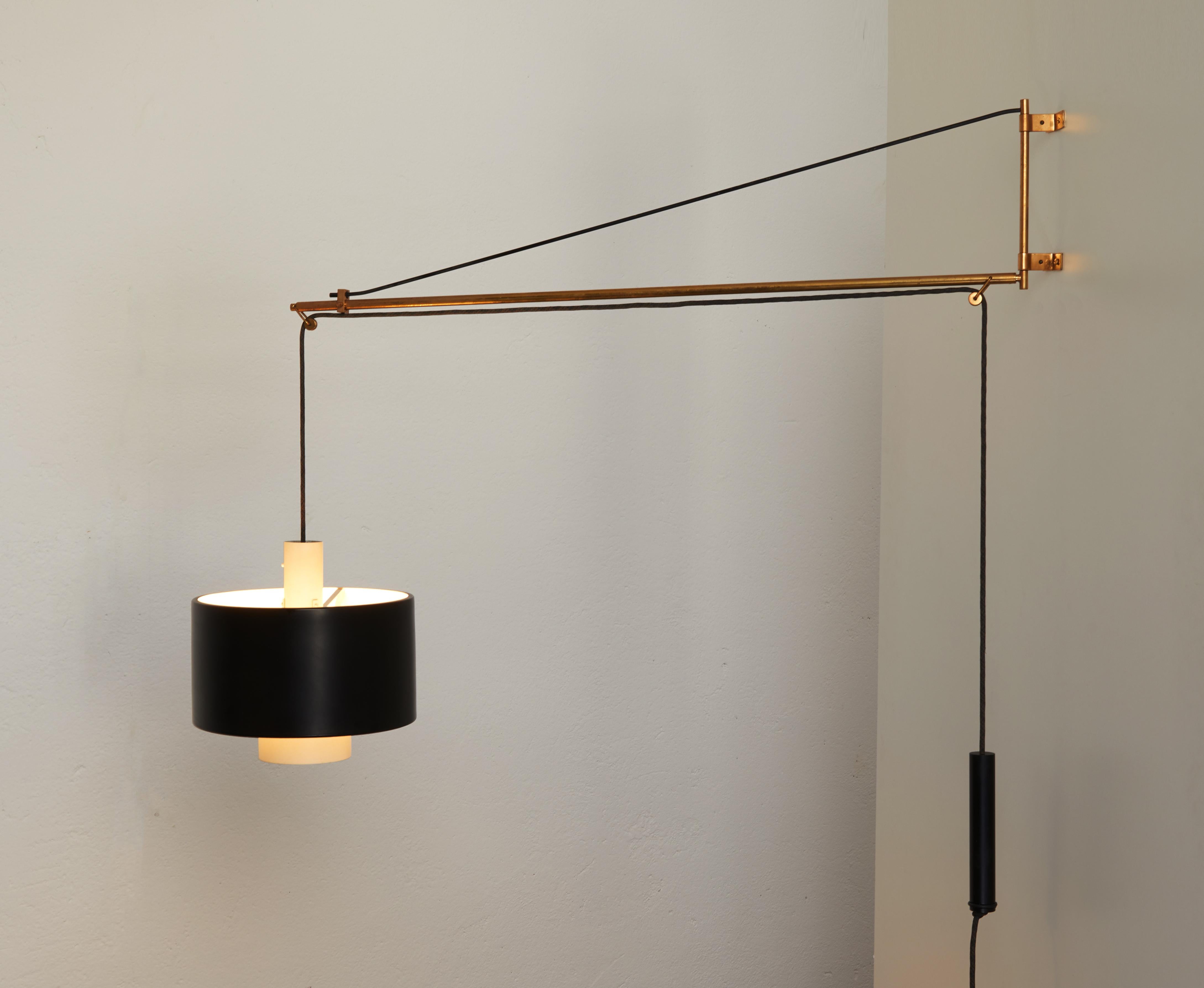 Large adjustable wall lamp model 2061 by Gaetano Scolari for Stilnovo 1954.

Brass structure composed of a telescopic arm and a pulley system with a counterweight which allows to adjust the height of the reflector.

The reflector is composed of