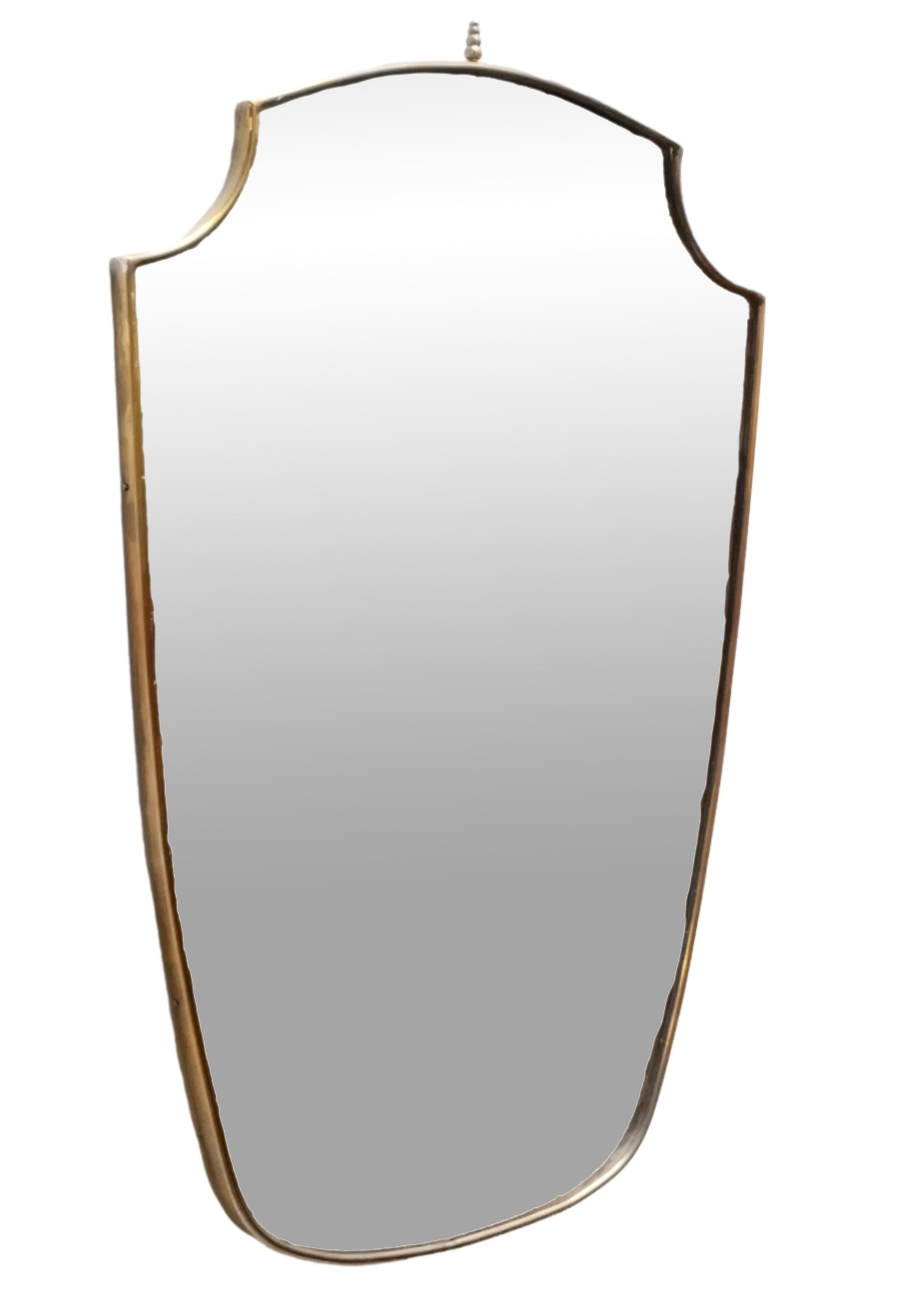 Wall mirror with brass frame, made in the 1960s in the style of Giò Ponti. The frame shows some signs of time.


