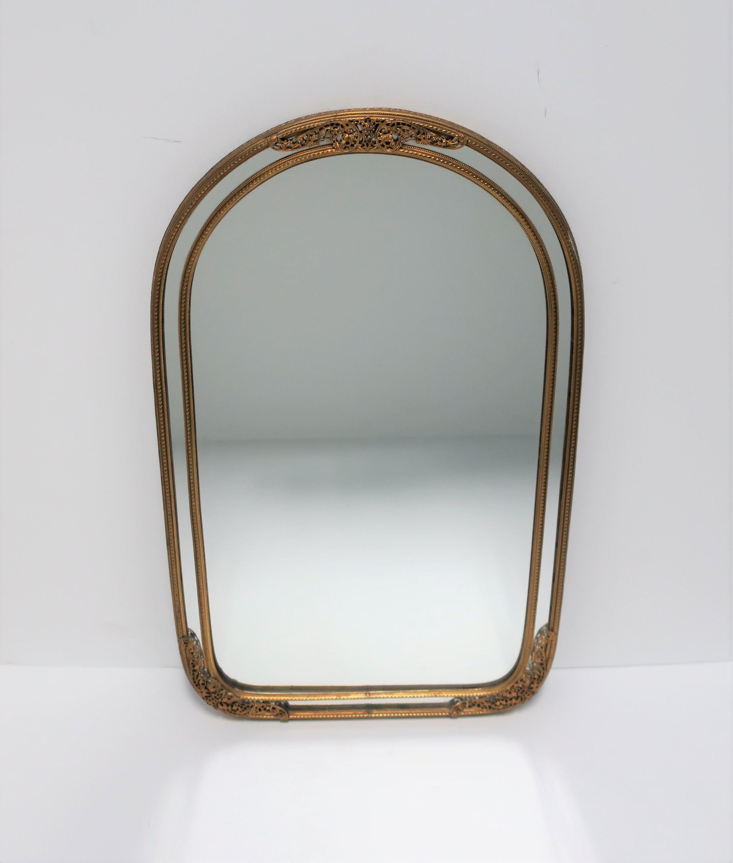 A beautiful and well-made European brass wall mirror, circa early to mid-20th century, Europe. Beautiful, small details are all around this quality brass frame. Mirror is on the smaller side of typical wall mirrors; piece would work well where a