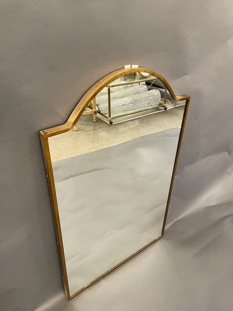 Wall mirror with brass frame, made in the 1950s in the style of Giò Ponti. The frame has some signs of ageing.