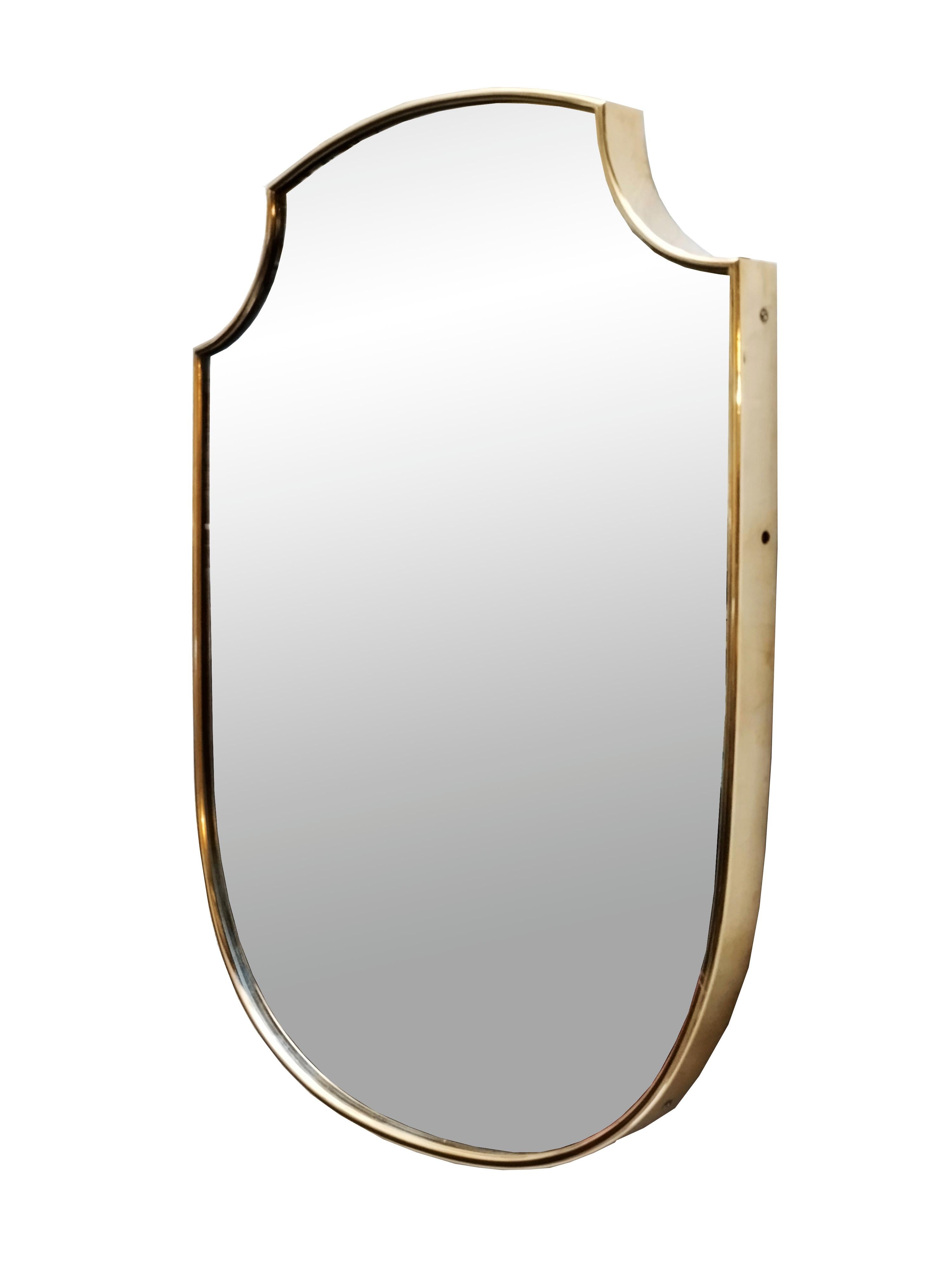 Italian shield wall mirror circa 1950s, solid brass with original patina, mirror has a dullness and beautiful patina due to time. In the manner of Gio' Ponti.
 