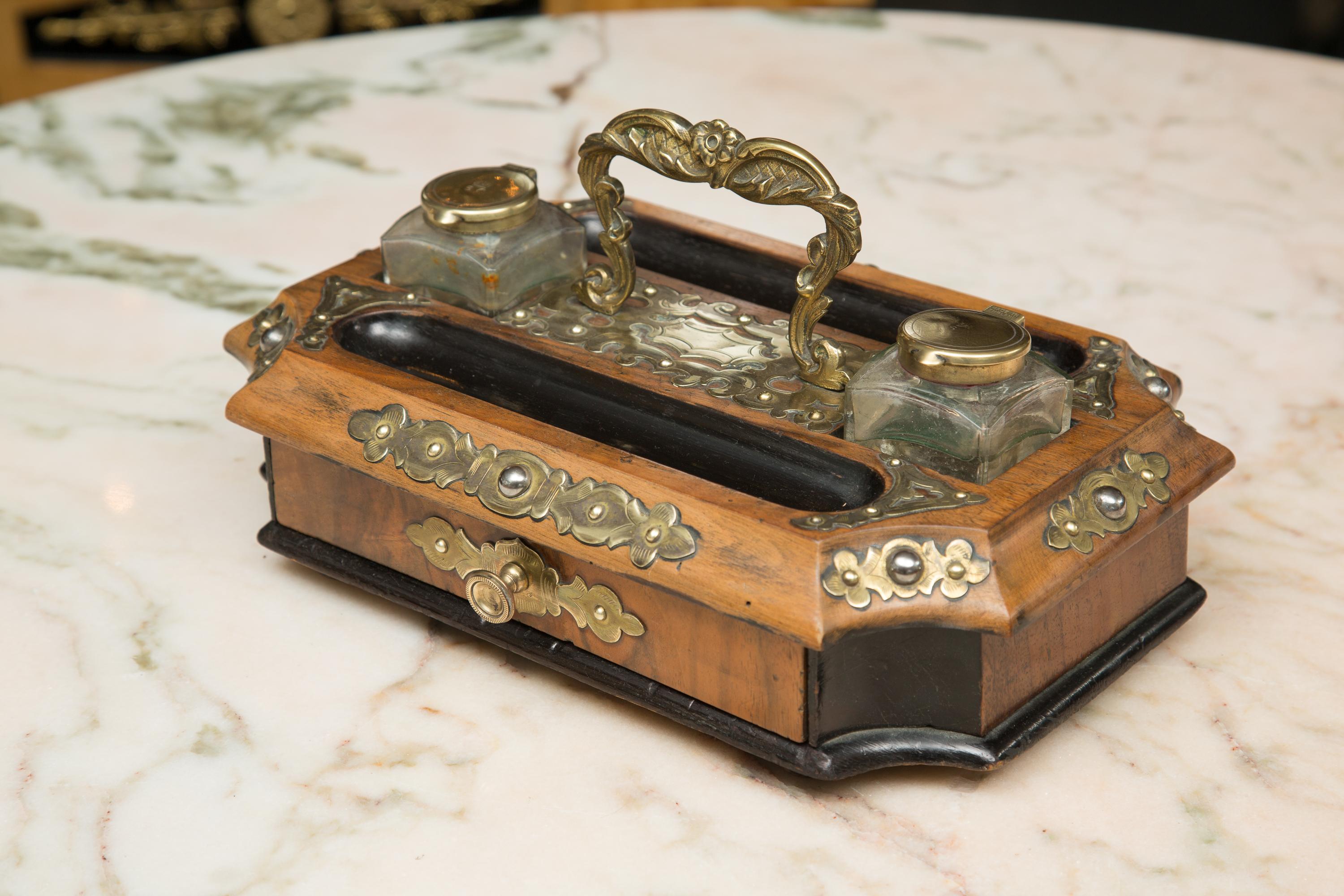 English Victorian inkwell set. This walnut set has been accented with an ebony color and an overall brass decoration,
mid-late 10th century.