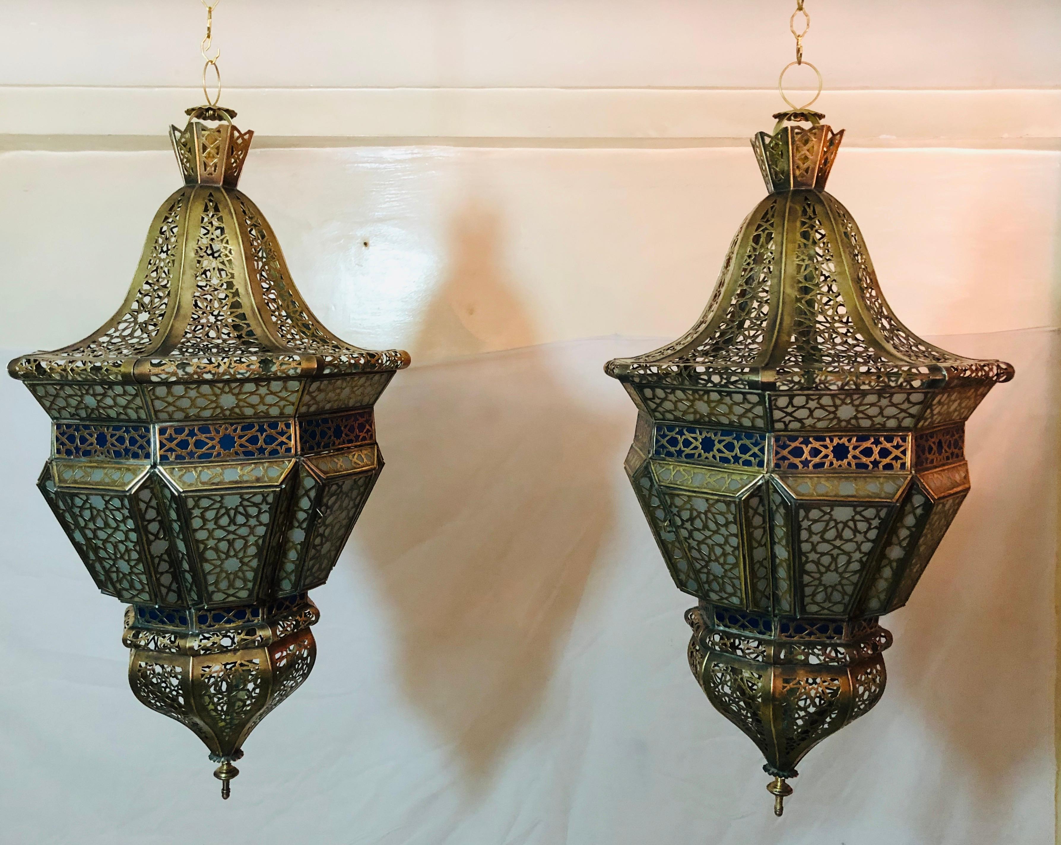 Add an exotic and stylish vibe to your living space with this beautiful pair of handmade Moroccan lanterns or chandeliers. The chandelier is made of fine antiqued gold brass, sanded glass in white and blue and features an intricate filigree