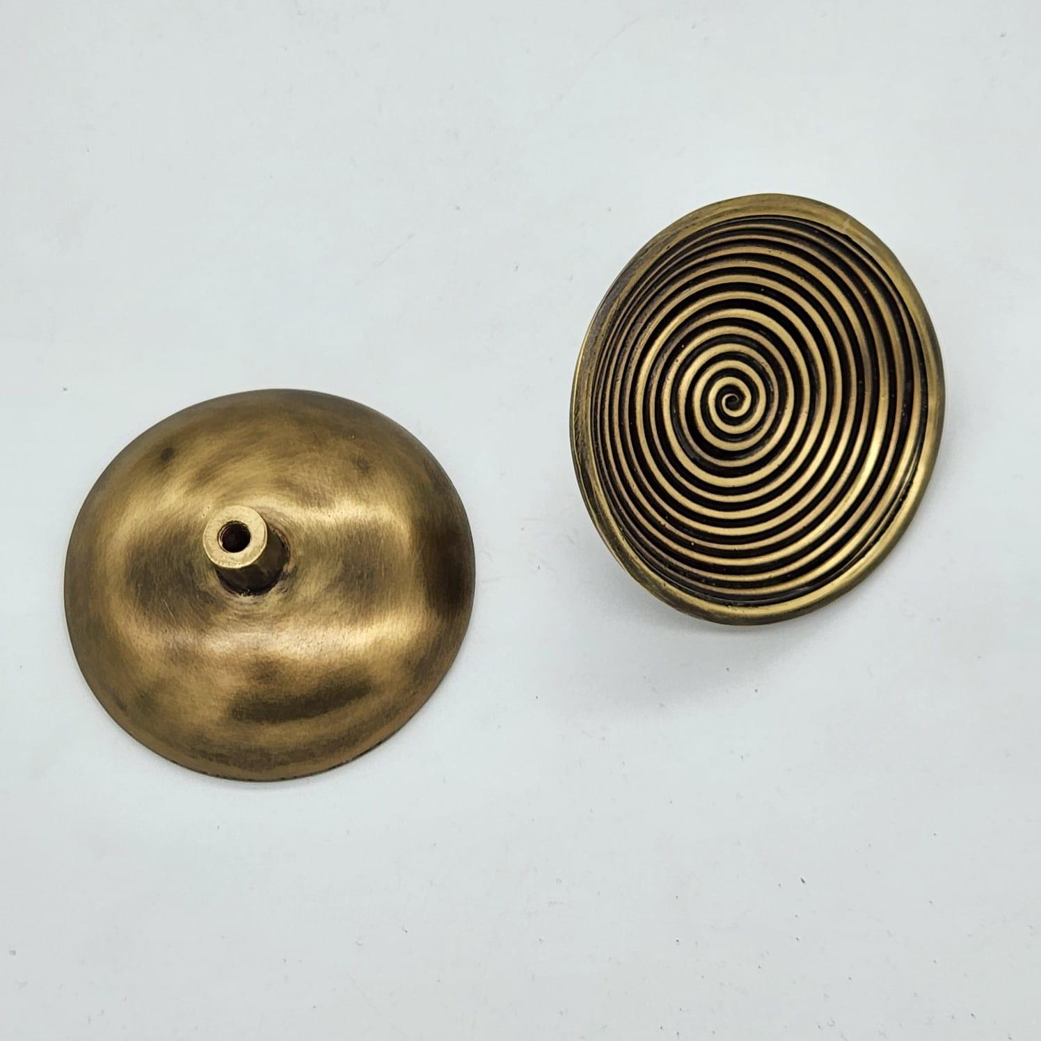 Alliant savoir-faire et élégance, la tirette de meuble PT/NO/03 réinterprète la sophistication des motifs orientaux grâce à un design circulaire méticuleusement travaillé. Ses anneaux concentriques, assemblés à la main avec précision, créent un