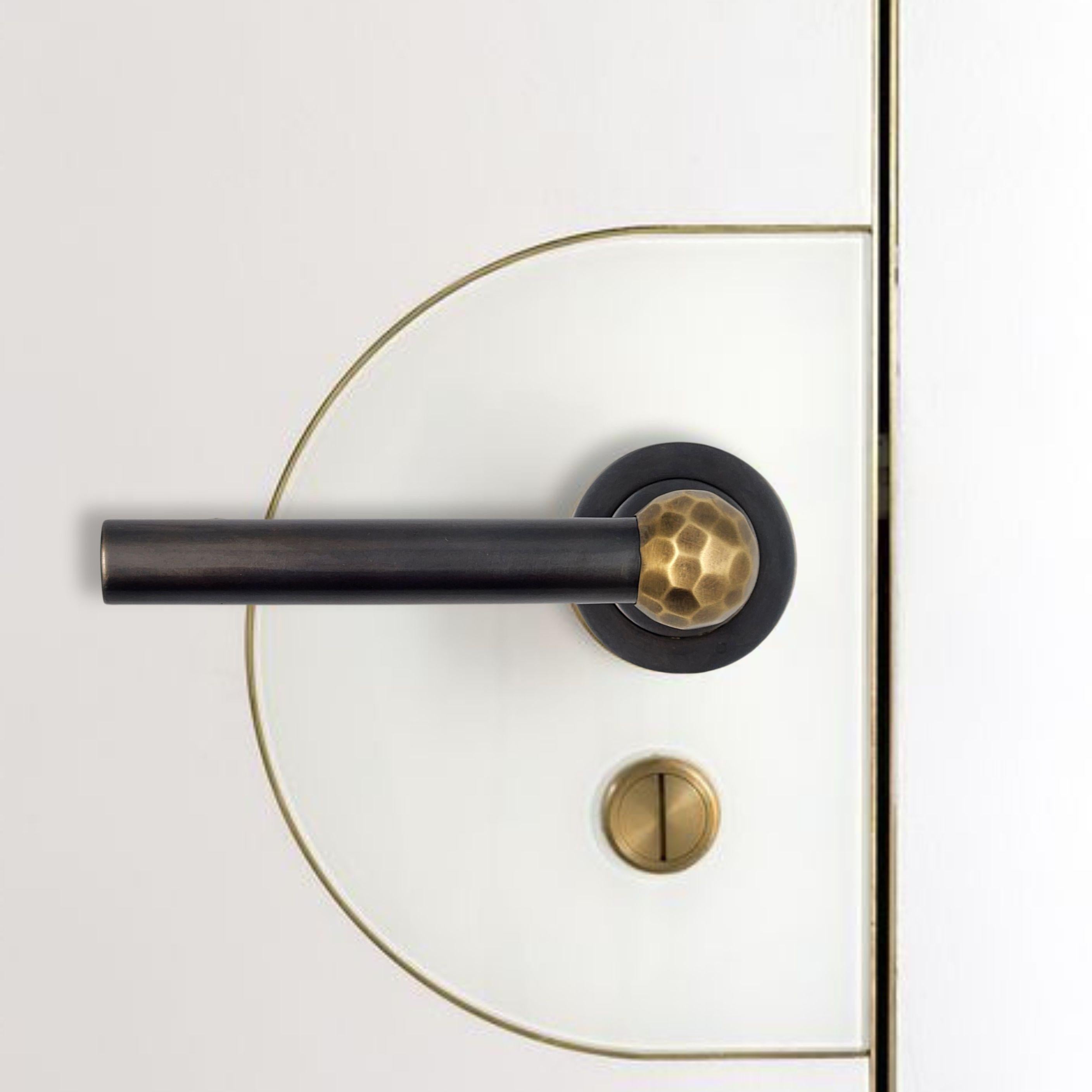 Dieser Türgriff aus patiniertem Messing in Rotguss und gehämmertem Messing schafft ein raffiniertes Gleichgewicht zwischen Design und Handwerkskunst. Er wird von erfahrenen Handwerkern in Handarbeit hergestellt und verbindet sorgfältig ausgewählte