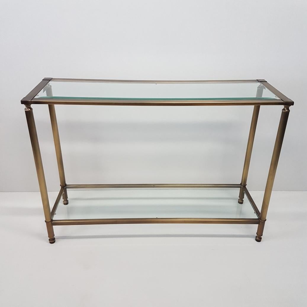 Brass with cut-glass French console table, 1980s.
Brushed brass frame with two cut-glass shelves.

Excellent condition.