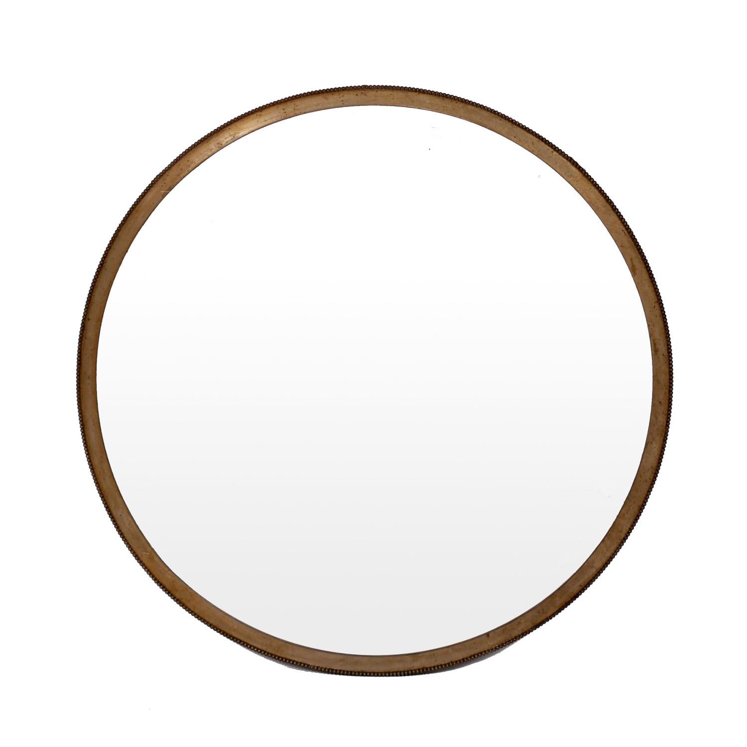 Industrial style porthole round mirror, made by The Brasscrafters, American, circa 1930s. These solid, well made mirrors were used throughout NYC in the 1920s-1930s. The metal frame has taken on a patinated bronze color.