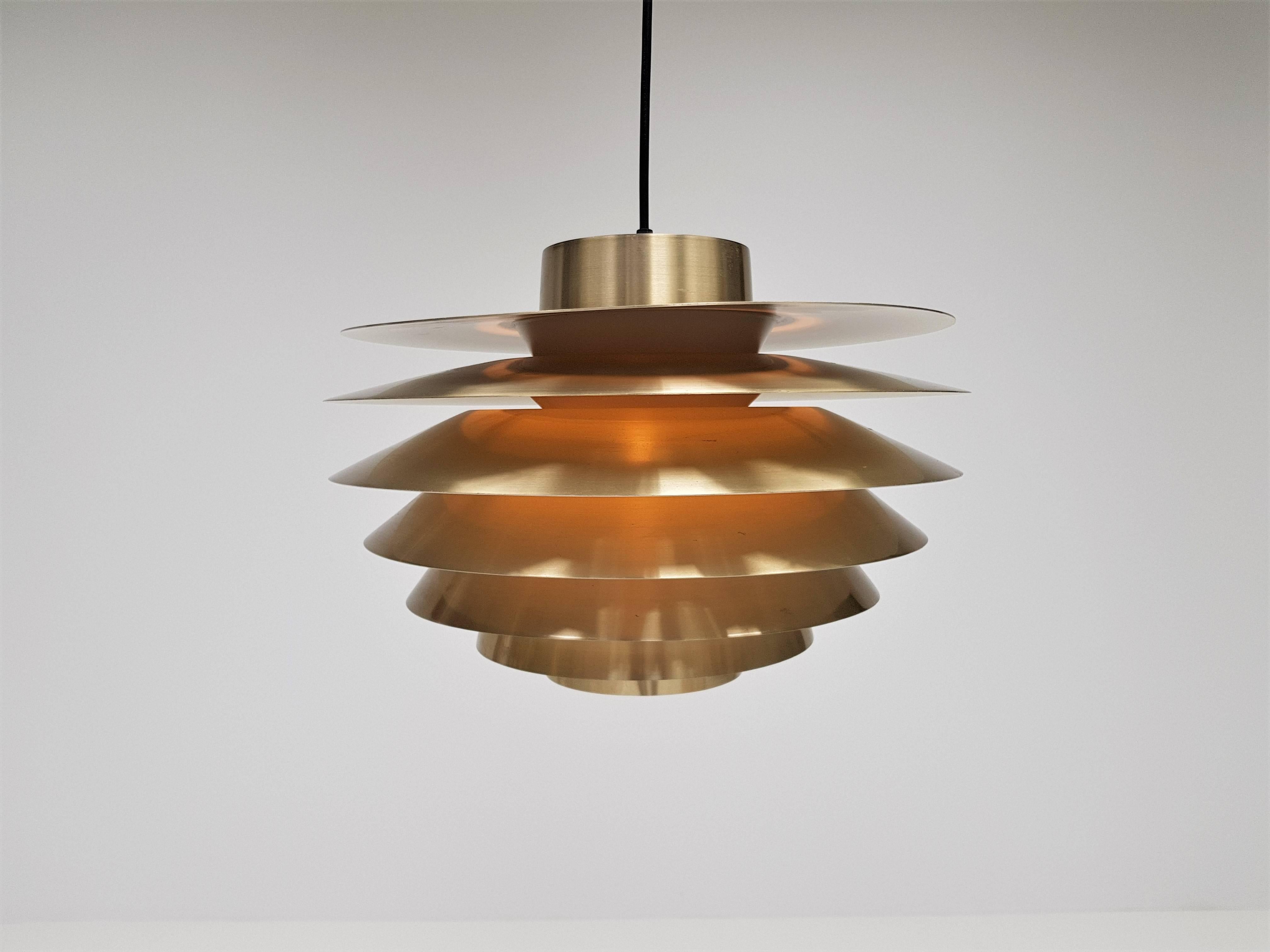 A vintage brassed Svend Middelboe Verona pendant light produced by Nordisk Solar, 1970s

Constructed from tiers of aluminium emitting a warm subtle glow when lit.

Fully working, rewired, safety tested and passed, supplied with a new minimal