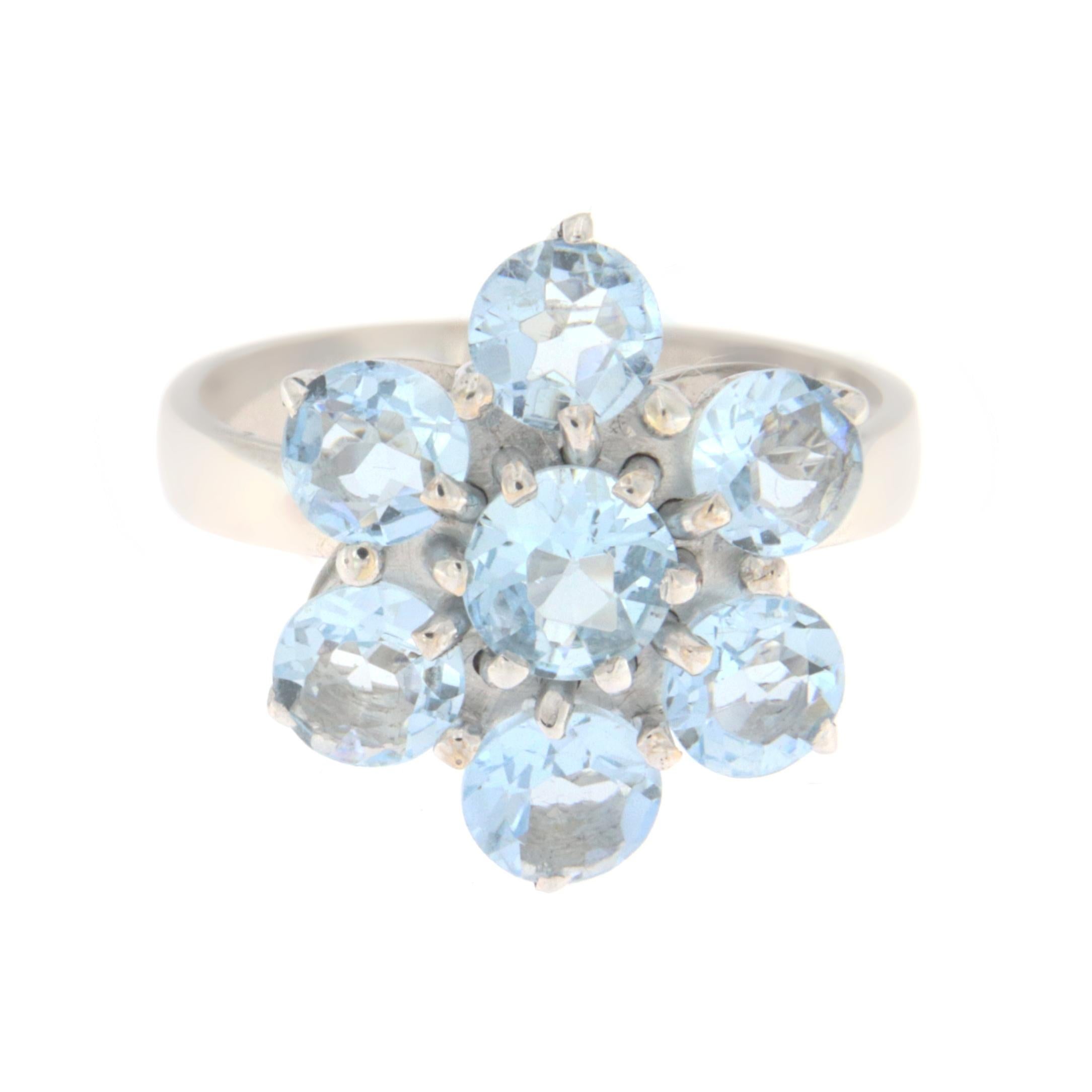 This delicate 18-karat white gold ring shaped like a little flower is a celebration of nature and elegance. Expertly designed, it features at its center 7 round aquamarines, each chosen for its sky-blue color reminiscent of serene skies and calm