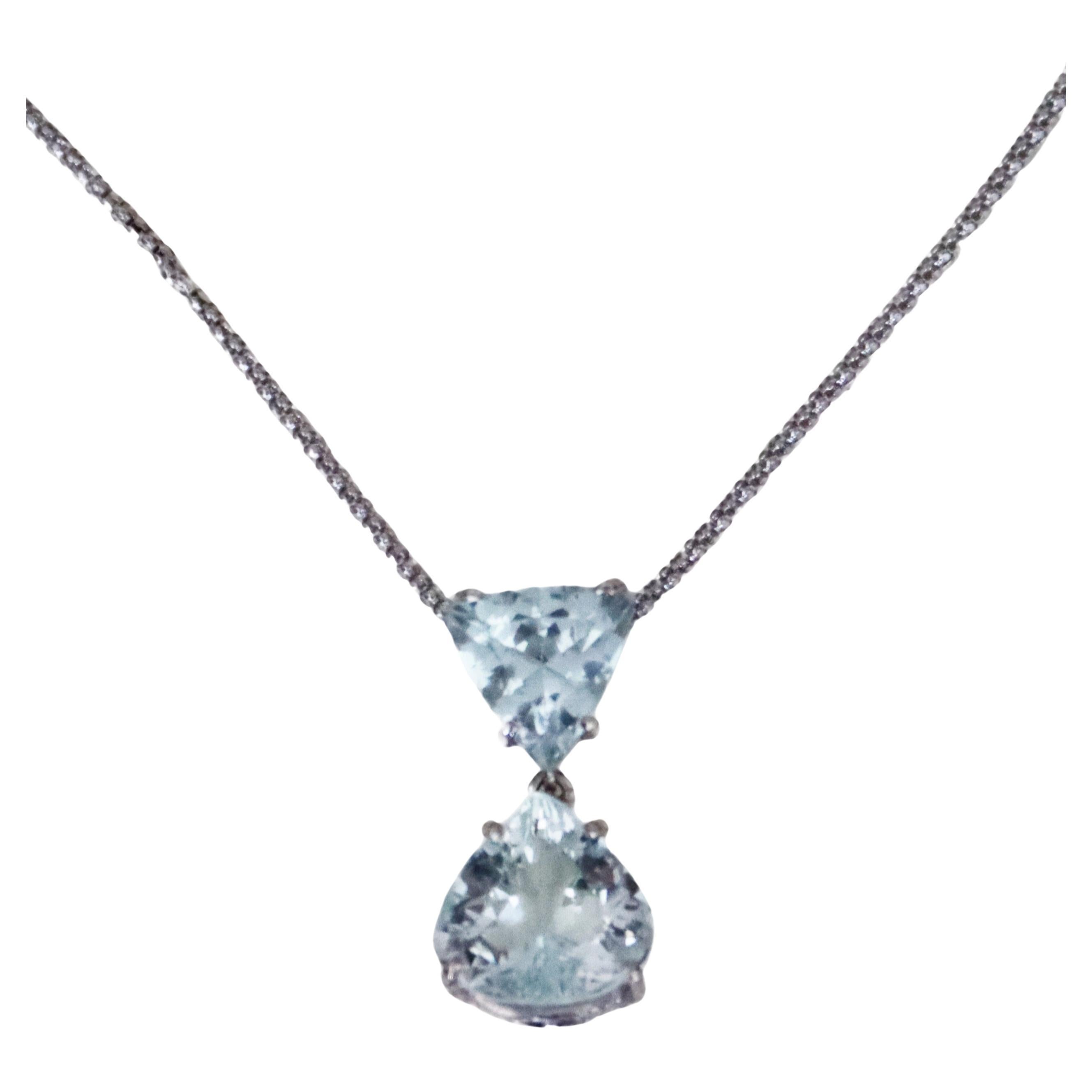 Questa elegante collana con ciondolo è realizzata in oro bianco 750‰ e presenta due splendide acquemarine brasiliane abbinate, una superiore a taglio triangolare e una inferiore a forma di pera, per un peso complessivo di 5,96 carati. Il design