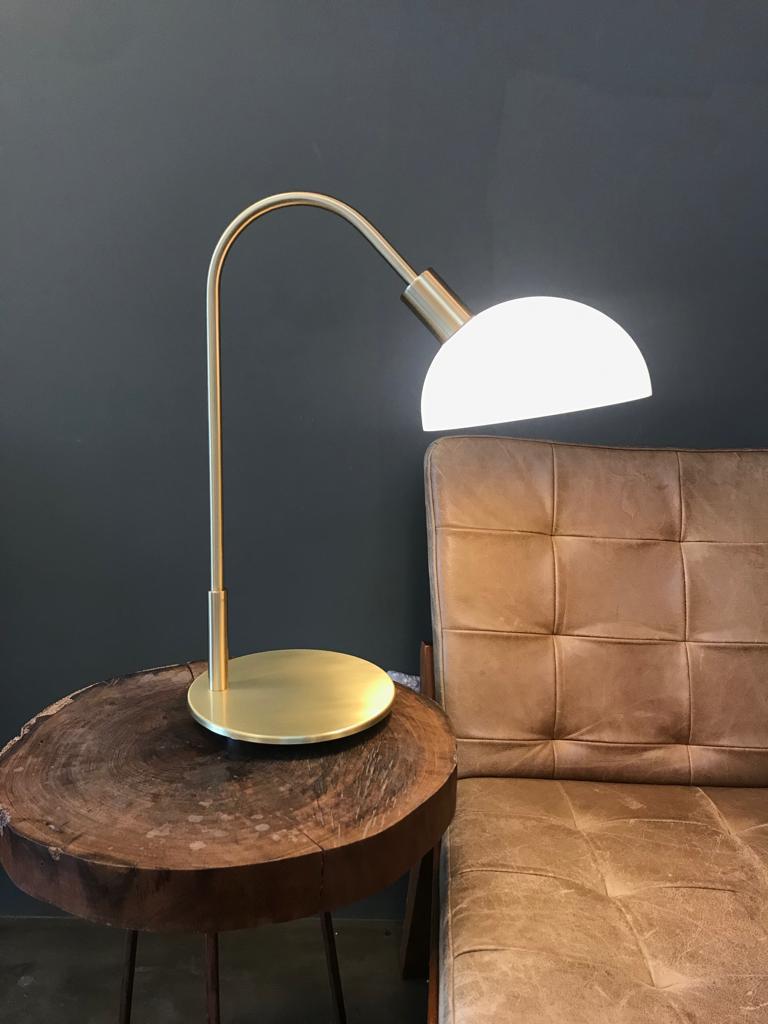 Cette lampe de table s'appelle Lichia. 
Le produit se compose d'un diffuseur acrylique rond et d'une base/structure en laiton.
La base est en acier et peut être brossée (elle prend une teinte dorée sans reflet) ou vieillie (elle prend une teinte