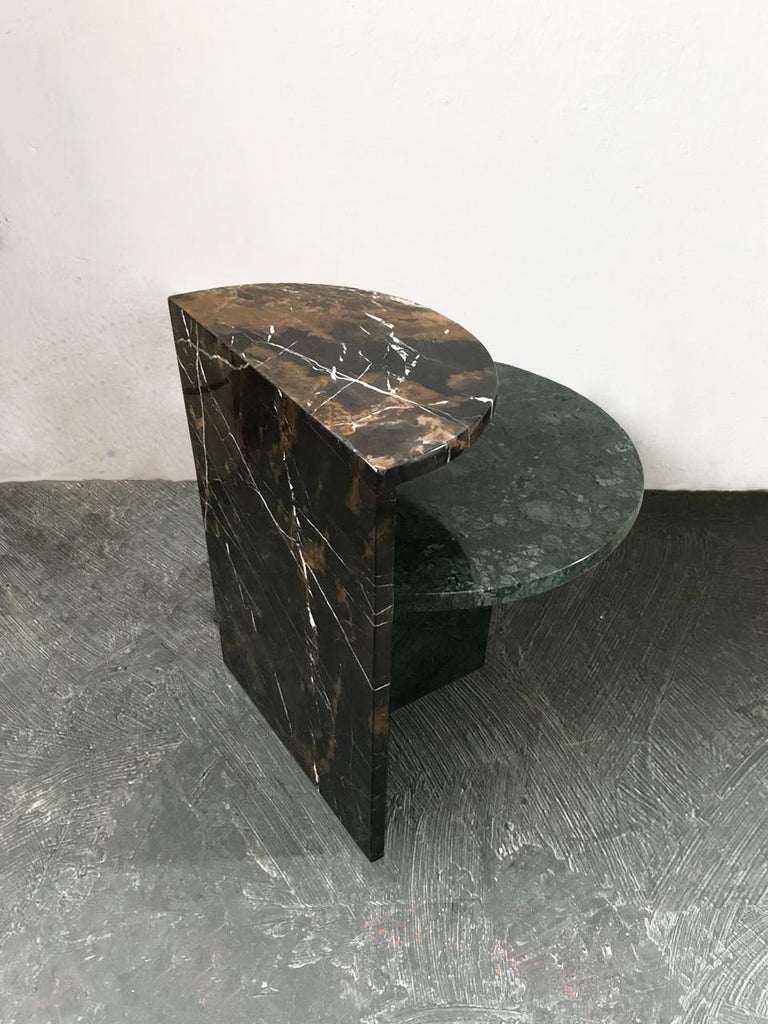 The café side table is made of marble and has simple geometric shapes. Its design with two circular shaped tops and two levels of height make the table a versatile piece that can be used as a coffee table or side table; and in composition with 02