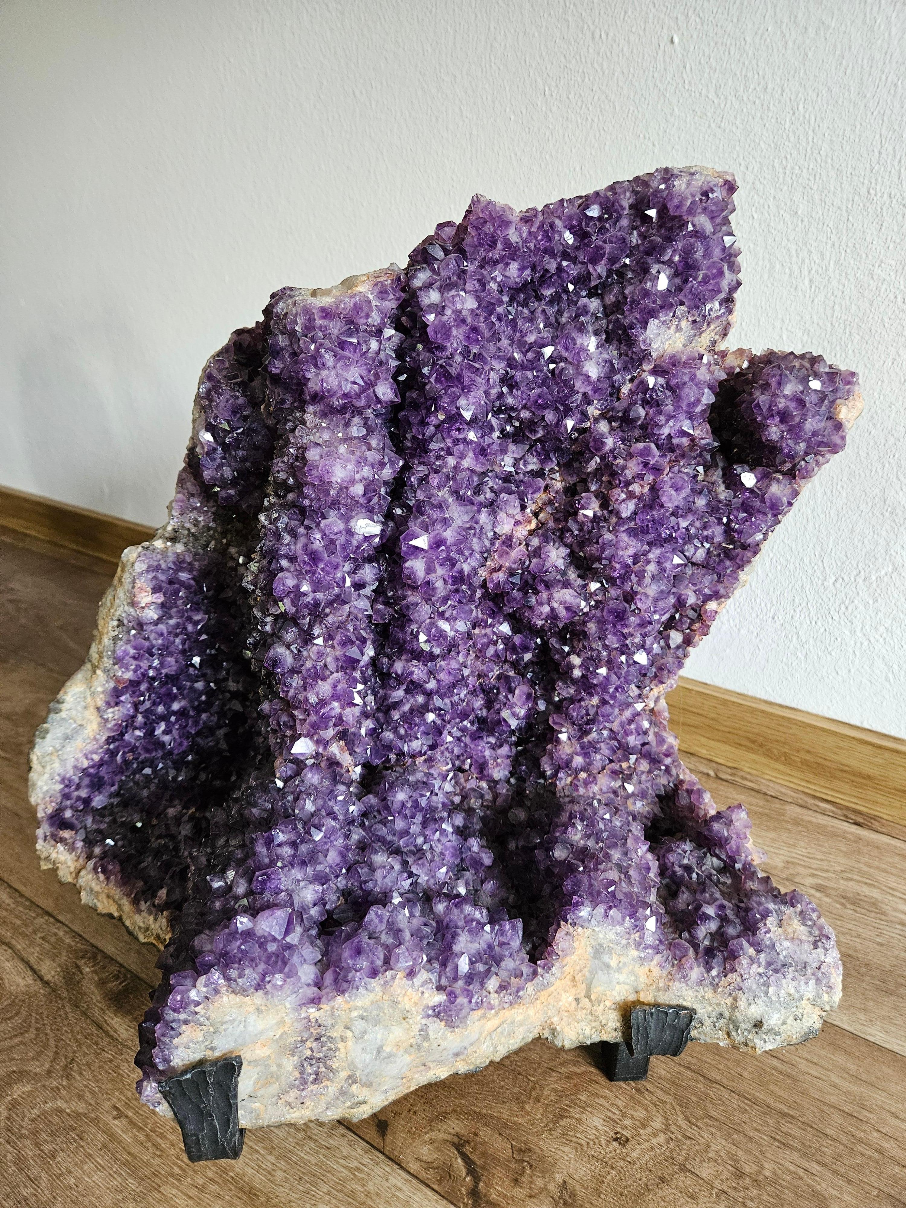 This Genuine Amethyst Cluster Geode from Brazil is a top quality natural formation of gem amethyst. It shows lustrous fully terminated crystals with highly reflective faces and a deep, transparent to translucent grape color.  
It comes with a metal