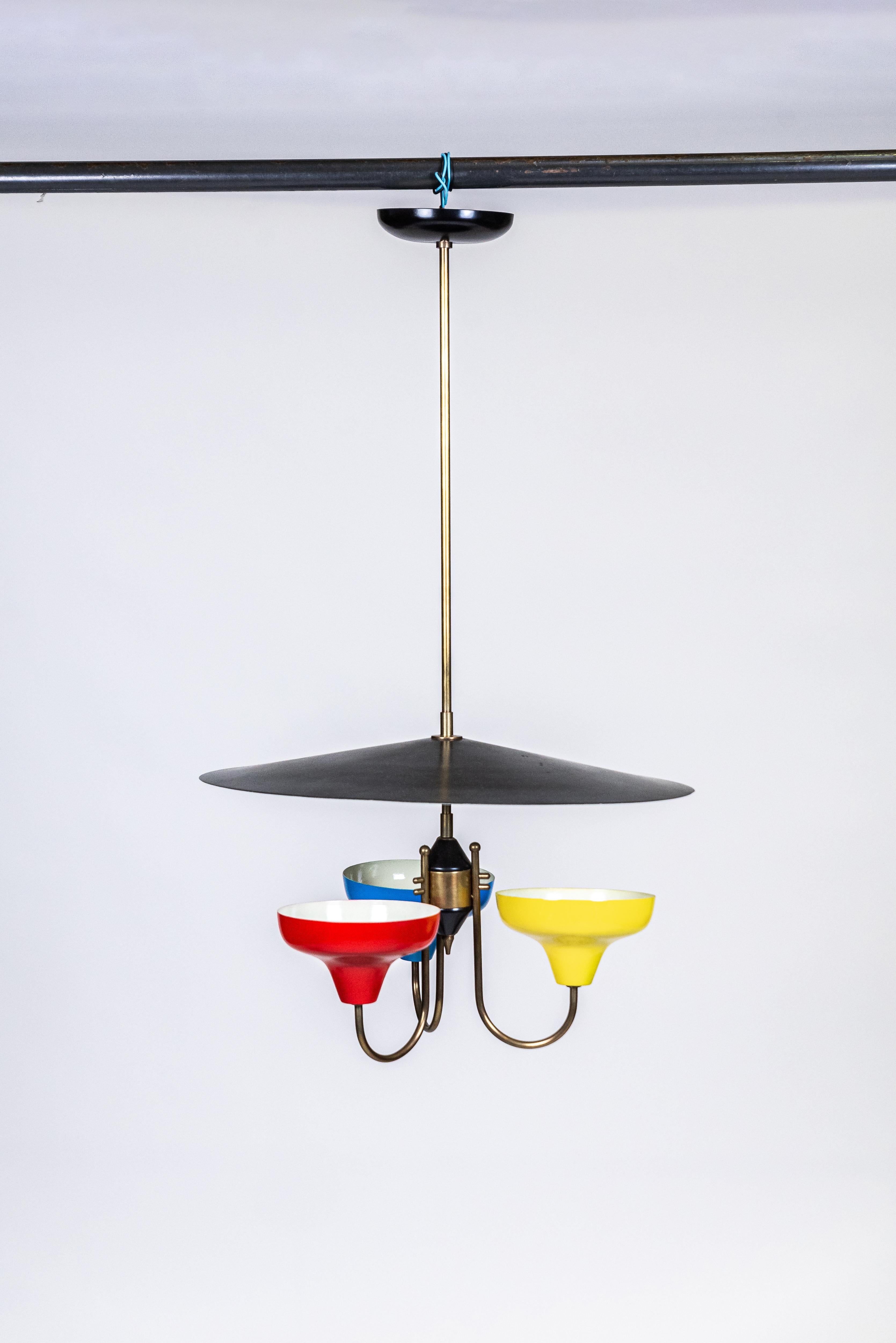 Brazilian design.
Chandelier, c. 1950.
Metal and brass.
Metal suspension and 3 cups in red, blue and yellow colors; tray and dome in white and black, support and details in gilded brass. In working condition.