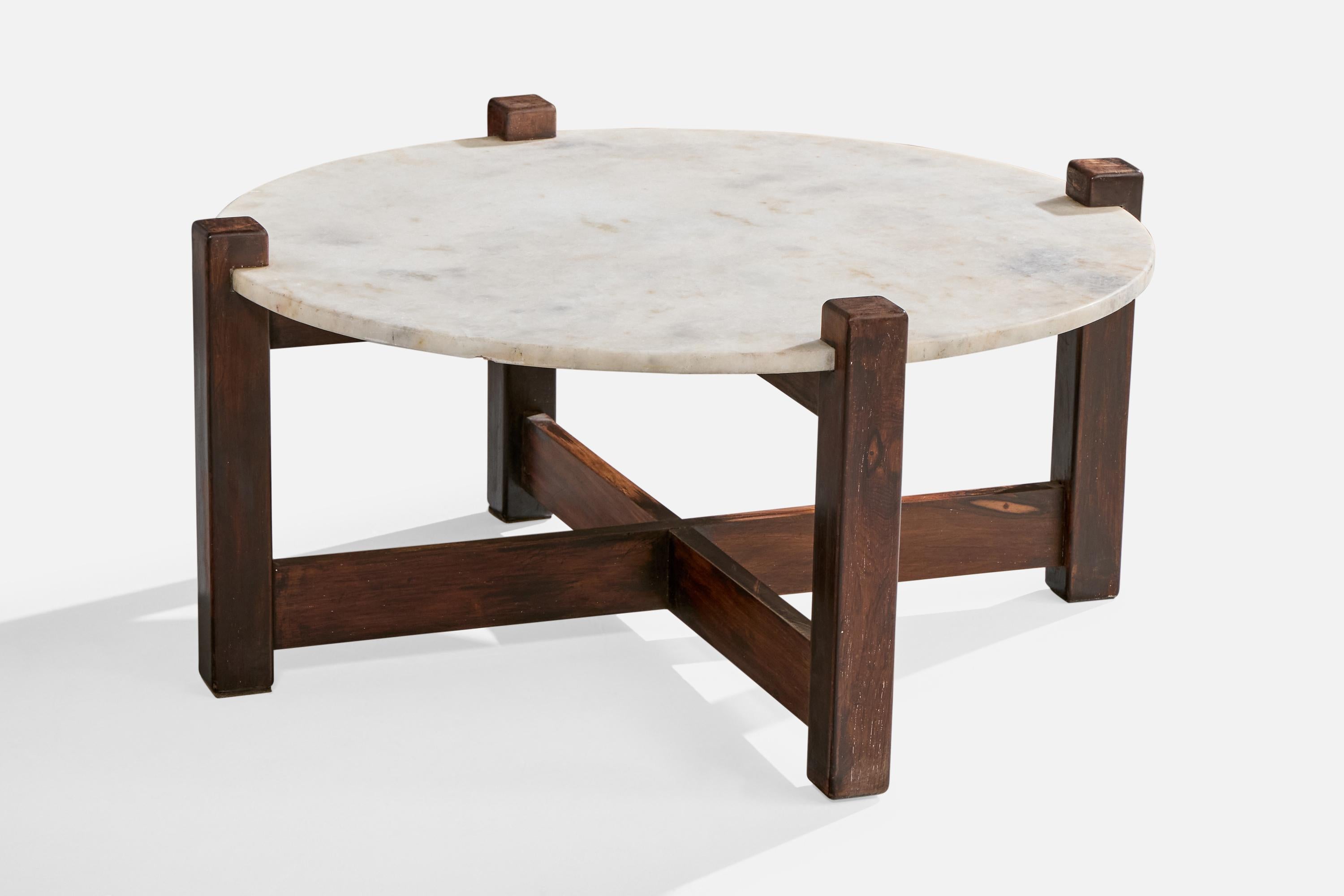 A wood and marble coffee table designed and produced in Brazil, c. 1960s.

Very light discoloration and scratching present on wooden legs.

A 1” H x .375” W x .125” area of loss of marble on bottom edge of top.

Large but faded cup stains present in