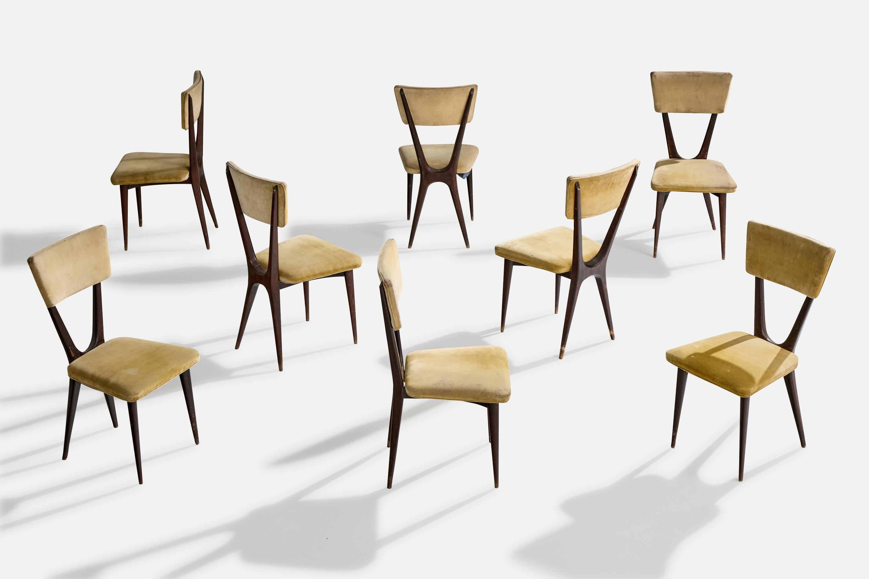 A set of 8 dark-stained wood and beige yellow velvet dining room chairs designed and produced in Brazil, c. 1950s.

Dramatic patina present to wood. Vintage fabric in distressed condition, ideally replaced.

Overall Dimensions (inches): 34.75” H x