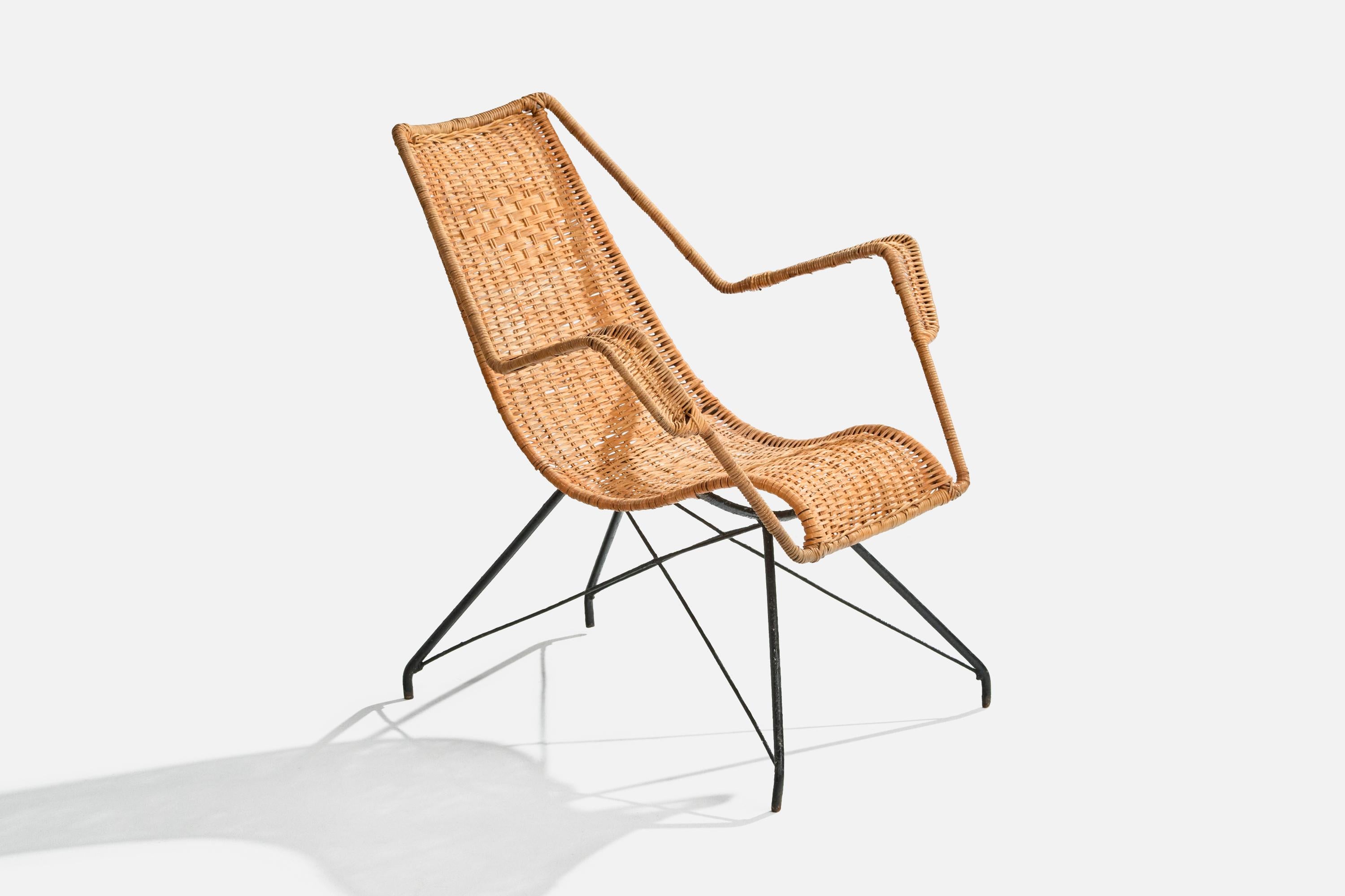 A rattan and black-painted iron lounge chair designed and produced in Brazil, c. 1950s.

Moderate oxidation to metal legs and frame.

Overall Dimensions (inches): 33” H x 40.625” W x 29” D

Seat Height (inches): 16.25”

Arm Height (inches): 25.75” 