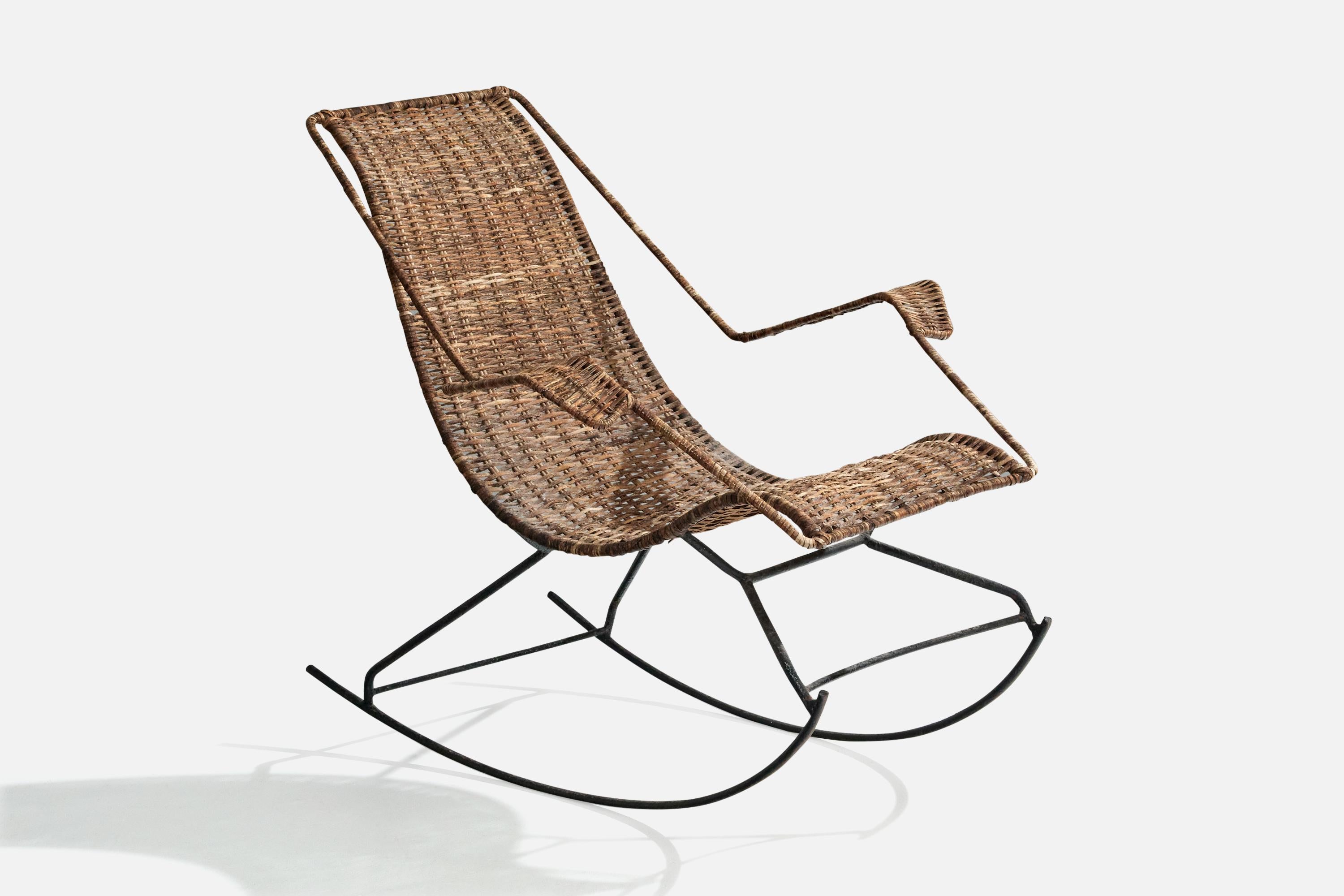 A black-painted iron and cane rocking lounge chair designed and produced in Brazil, c. 1950s.

Heavy oxidation to iron legs and frame.

Overall Dimensions (inches): 33.625” H x 31.5” W x 36” D

Seat Height (inches): 18” 

Arm Height (inches): 24.5”