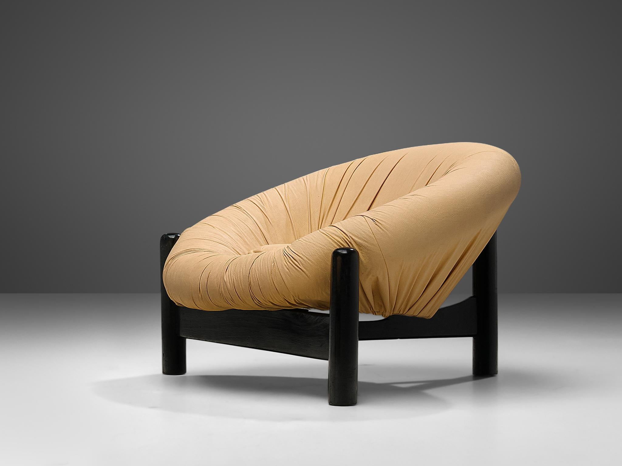 Lounge chair, leather, lacquered wood, Brazil, 1970s

This bulky Brazilian lounge chair consists of a round shell that forms a ring around the seat. The beige camel upholstery is tufted around the shell in dynamic folds. The shape invites to take a