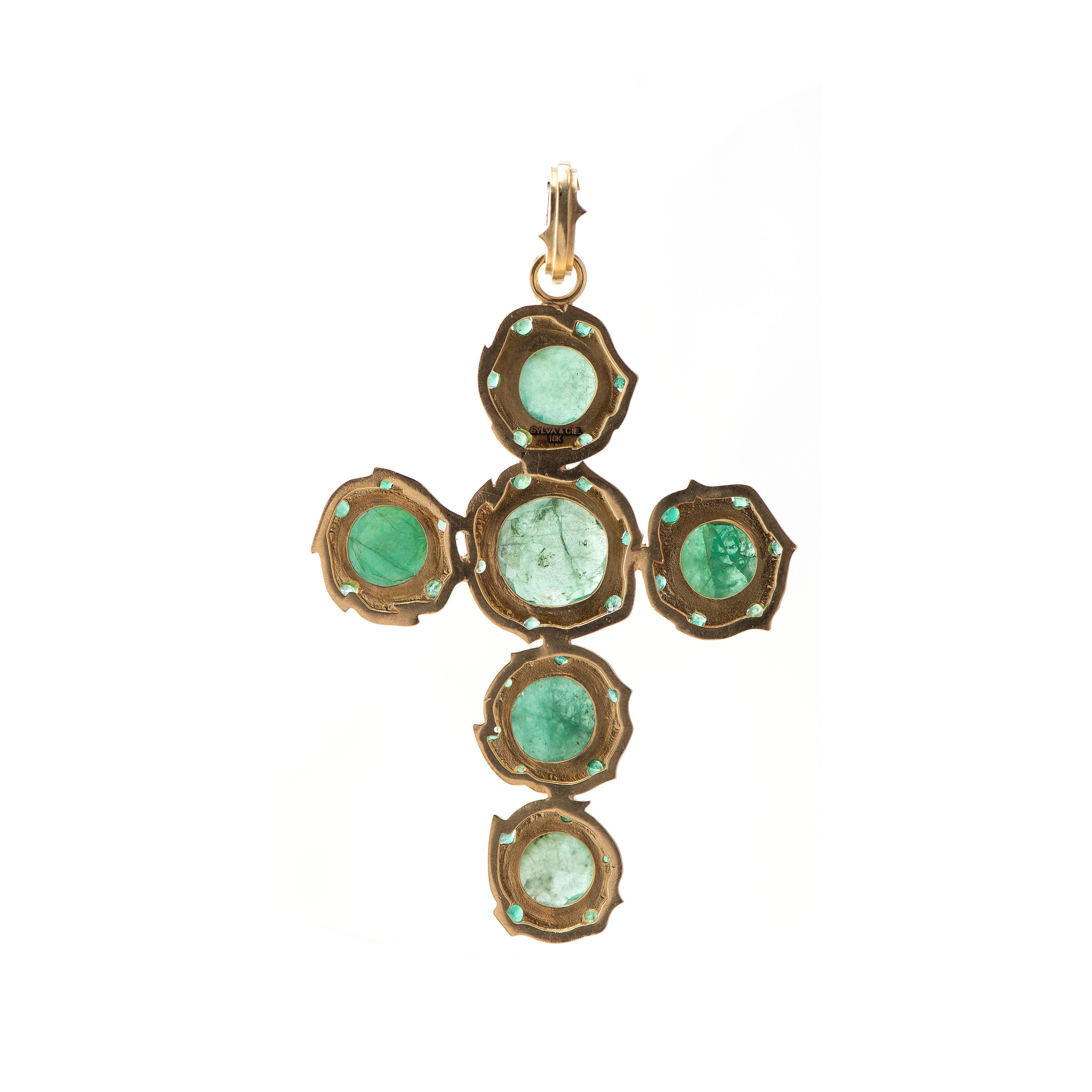 A familiar symbol in a creative iteration, these round Brazilian emerald slices are a beautiful brilliant green.  Surrounded by 18k yellow gold bezels with small set emerald melee, this pendant is a stand-out piece.  Wear on a long chain for a