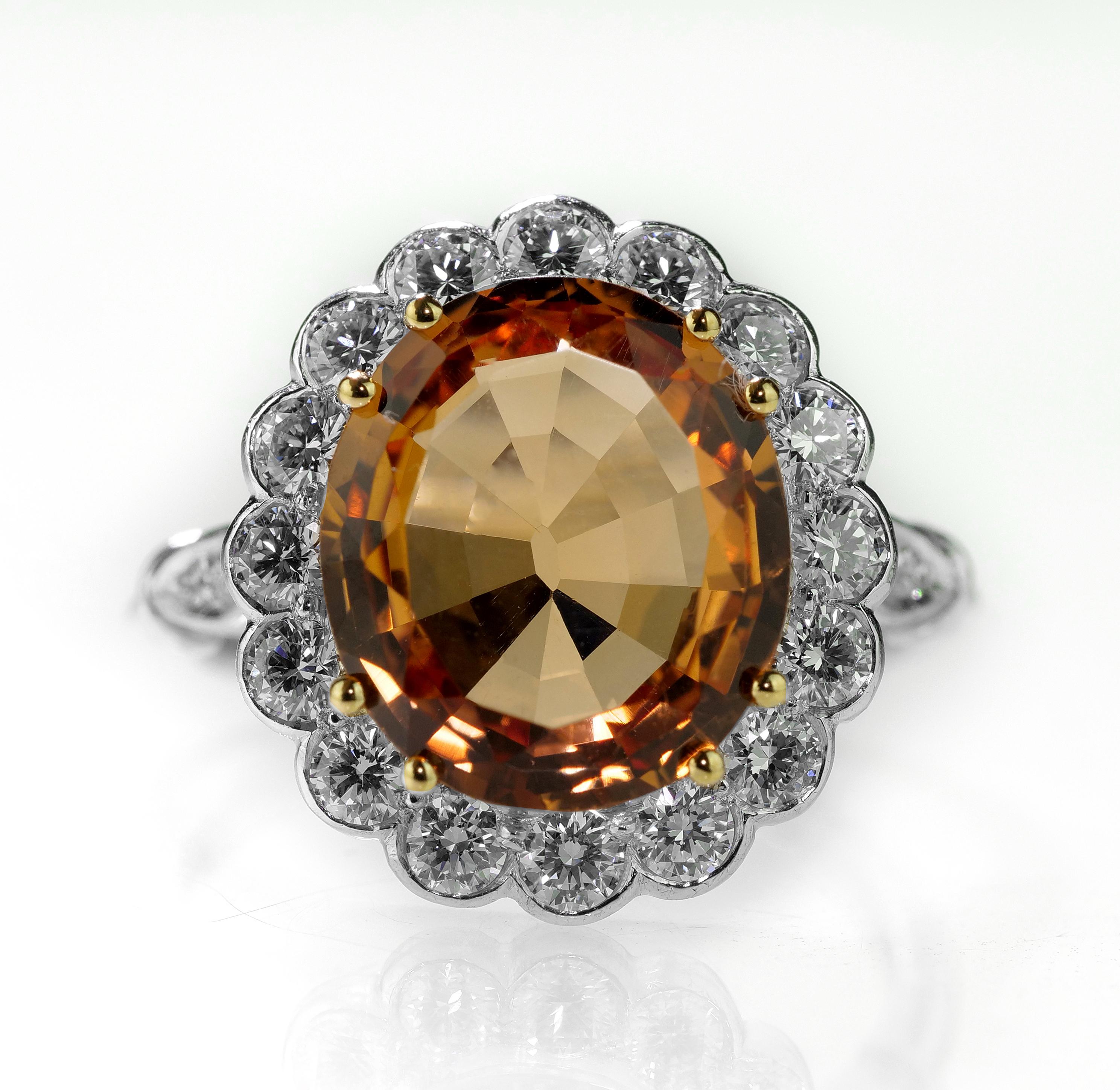 Centering orange colour Brazilian Imperial topaz surrounded by diamonds set in platinum. 
1 x Oval shape faceted topaz, approximate weight 4.85 carats
28 x round brilliant diamonds, approximate total weight 0.32 carats, assessed colour G/H, assessed