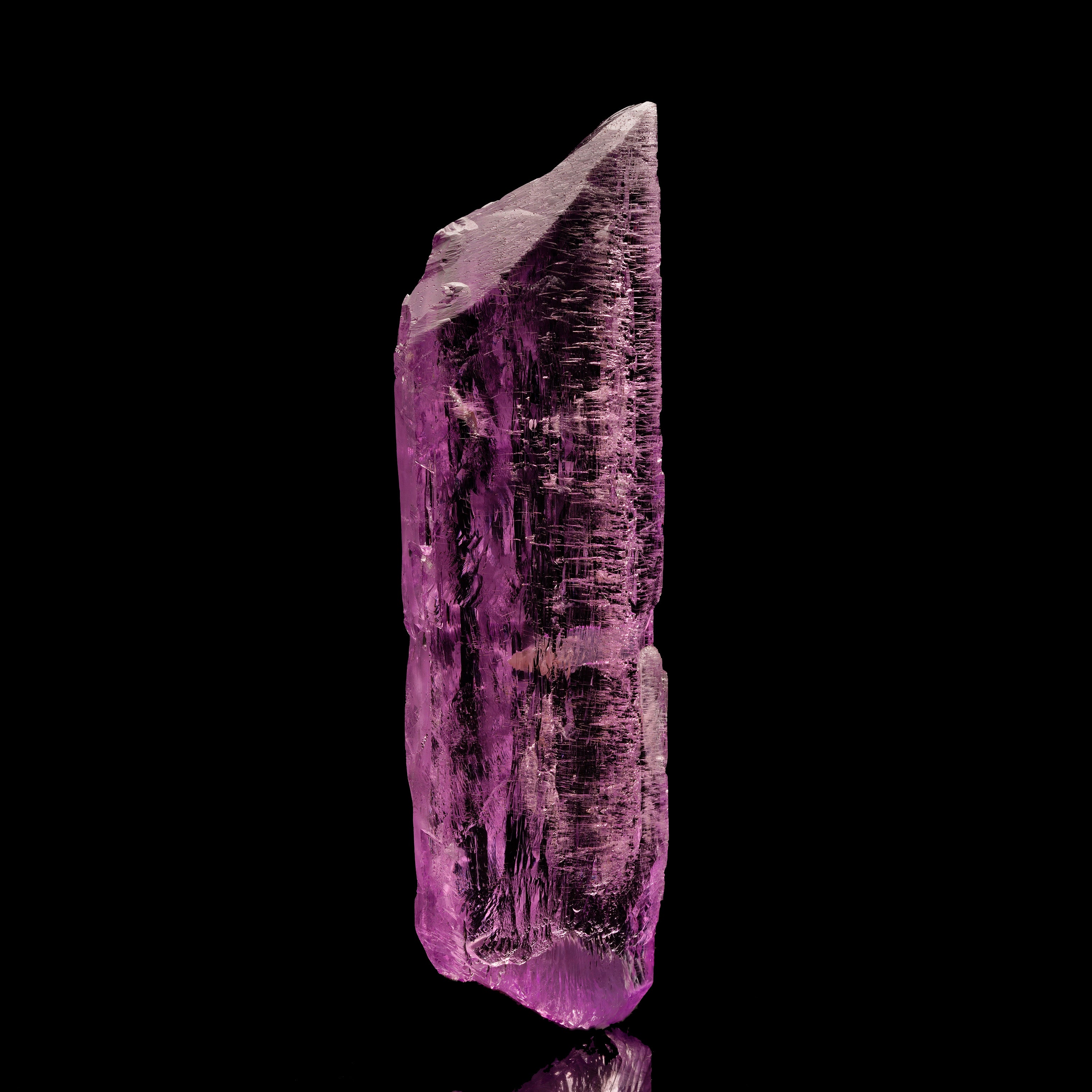 A classic Brazilian Kunzite specimen showing interesting hydrothermal etching on the glassy faces of this uniquely-shaped crystal. Pristine! The piece is a floater with no point of attachment and it radiates a lovely pastel pink color that is much