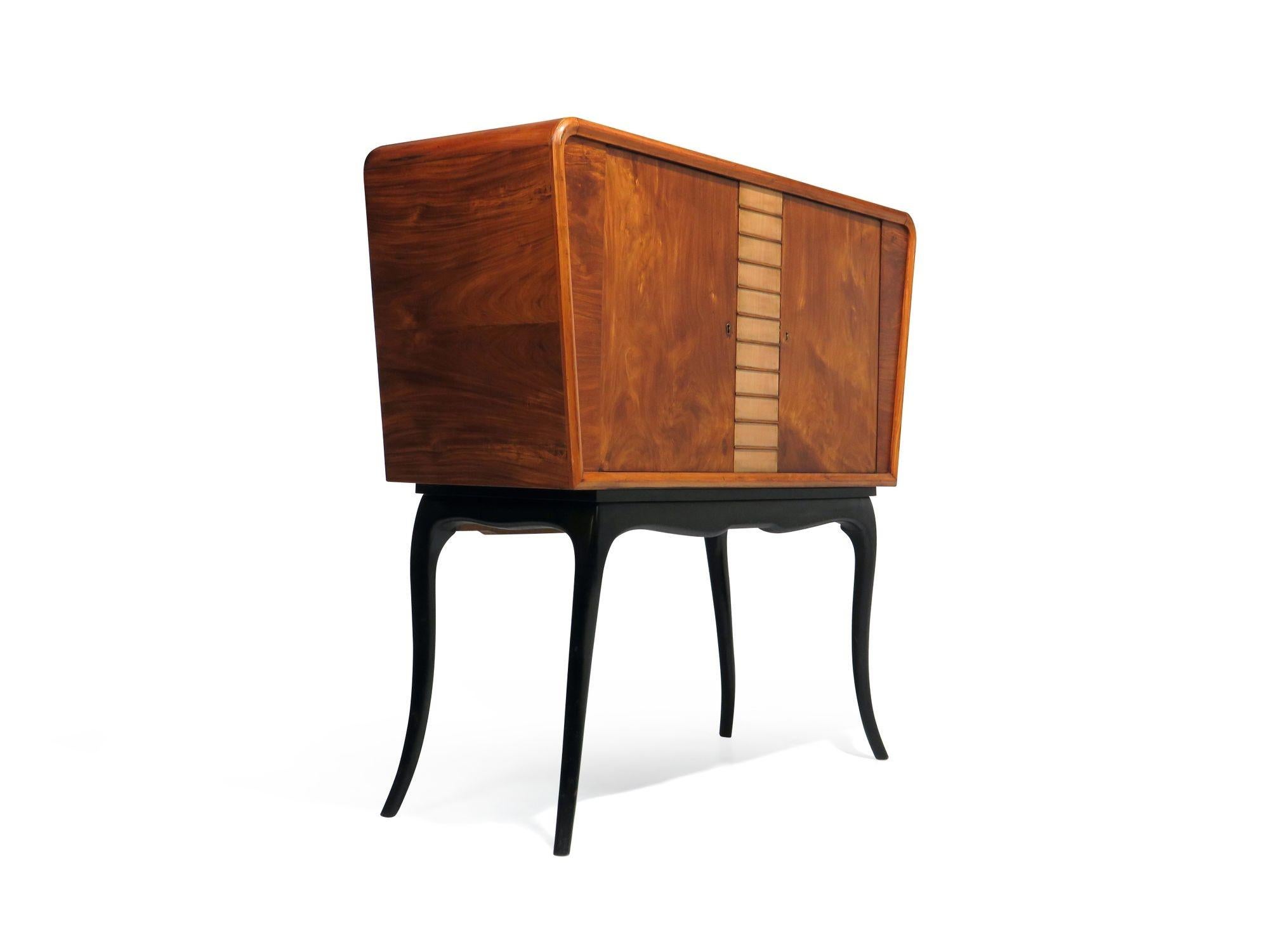 Brazilian bar cabinet designed by Guiseppi Scapinelli, 1960 Brazil. Crafted of caviuna wood with locking book-matched doors and interior lined with etched diamond pattern mirrors. Raised on dramatic curved legs in an ebonized finish. The cabinet is