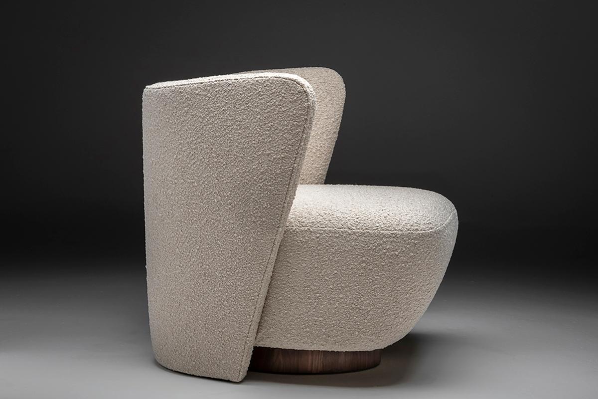 The Espaldar lounge chair was inspired by the feminine and futuristic but elegant curves of the 1960s, with upholstered fabric body and wooden base. 
Measurements: 87cm x 84cm x 69cm H.
 