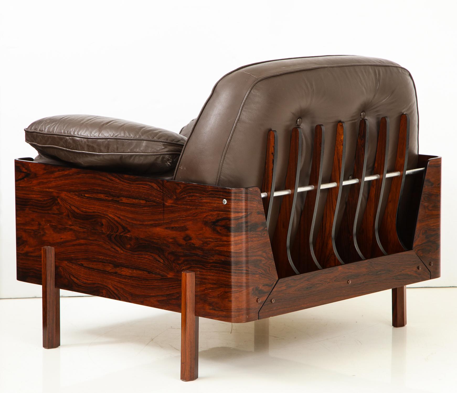 Loungesessel aus stark gemasertem Jacaranda-Holz mit einer Reihe von skelettartigen Flossen entlang der Rückenlehne, die durch eine Aluminiumstange verbunden sind, und originalen braunen Lederkissen. Ein visuell beeindruckendes Design, hergestellt
