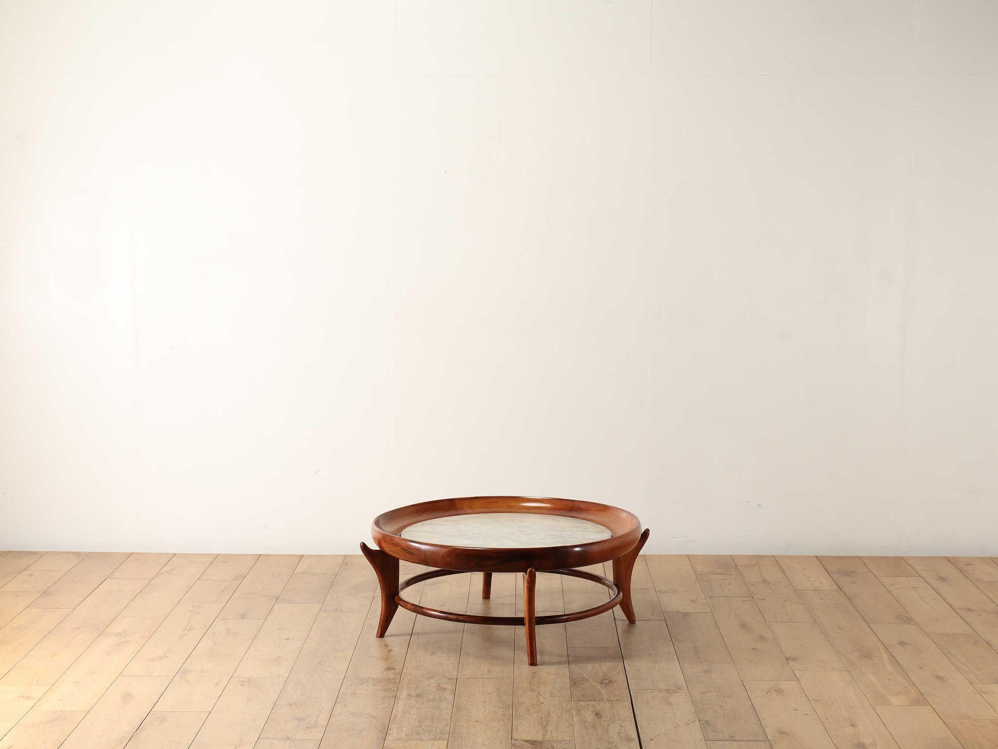 This round coffee table was made in Brazil and is made of Caviuna wood with white marble. Caviuna wood is famous as a material used extensively in furniture making during this Brazilian mid-century period, and is said to be shiny, hard and resistant