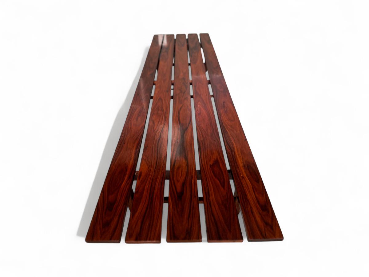 Ce banc est fabriqué en bois de rose brésilien (également connu sous le nom de jacaranda), et il présente une tonalité étonnante avec des veines de bois naturelles. En outre, le bois a été remis à neuf et est désormais en excellent état. Le banc